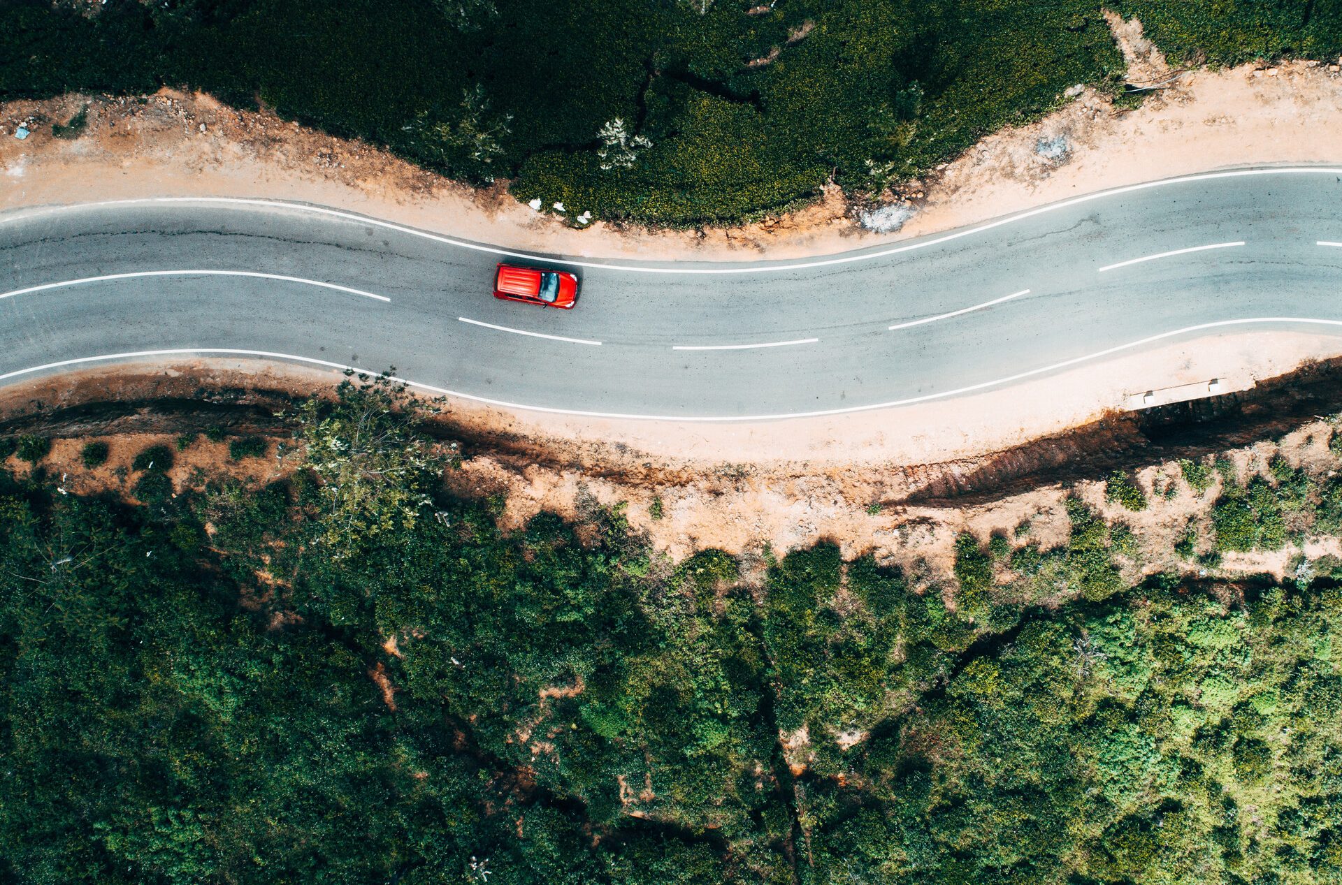 Vista de pájaro de un coche en una carretera muy pintoresca.