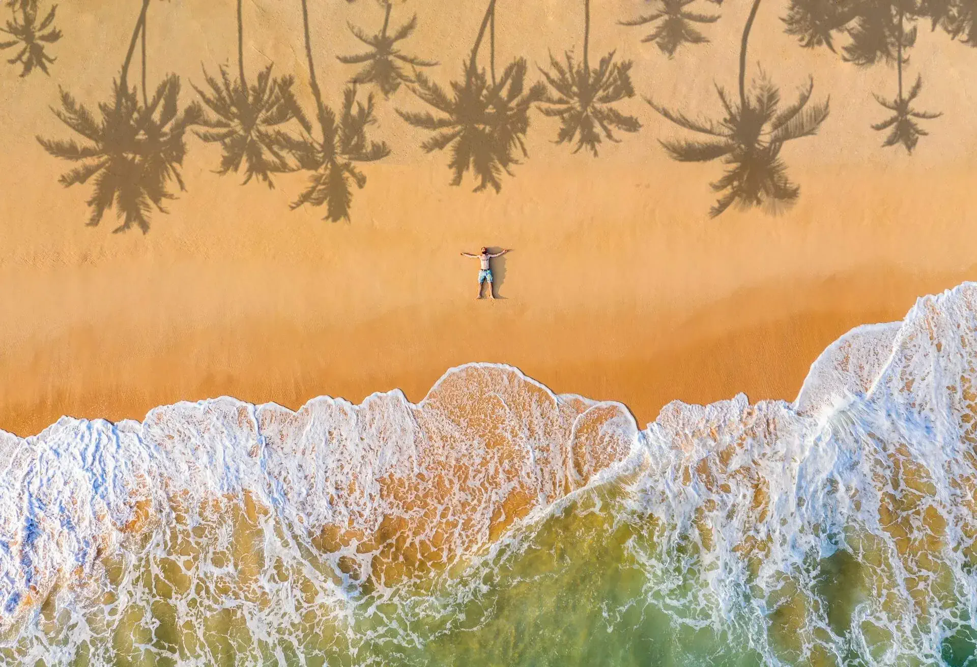 MAN LYING ON SANDY BEACH in Sri Lanka