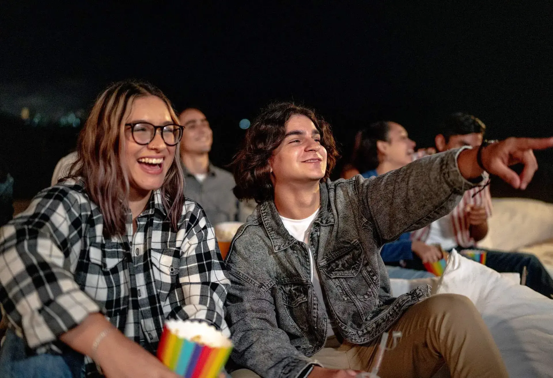 Young couple watching a movie at the outdoors cinema 