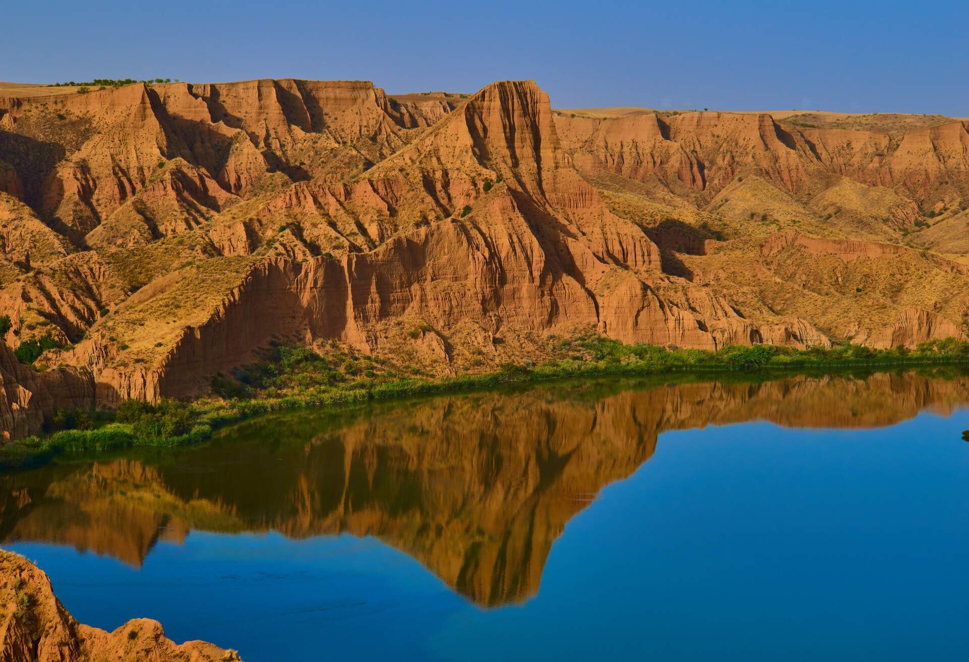 Beautiful landscape with red rocks and lake in the Barrancas de Burujon, Toledo, Spain in Burujón, CM, Spain