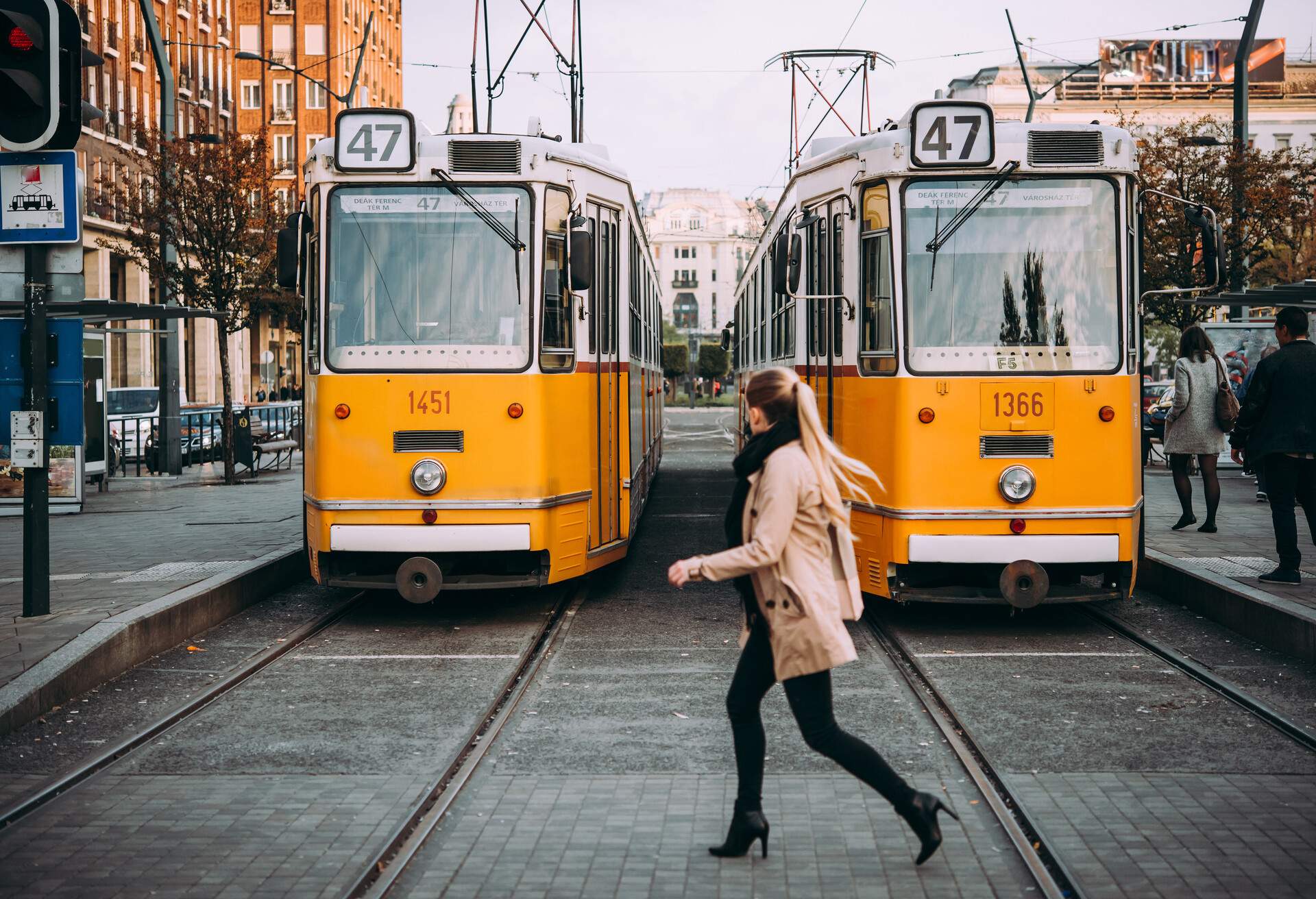 Young woman crosses the street at a tram stop in Budapest, Hungary.; Shutterstock ID 664525810; Purpose: Product; Brand (KAYAK, Momondo, Any): Momondo