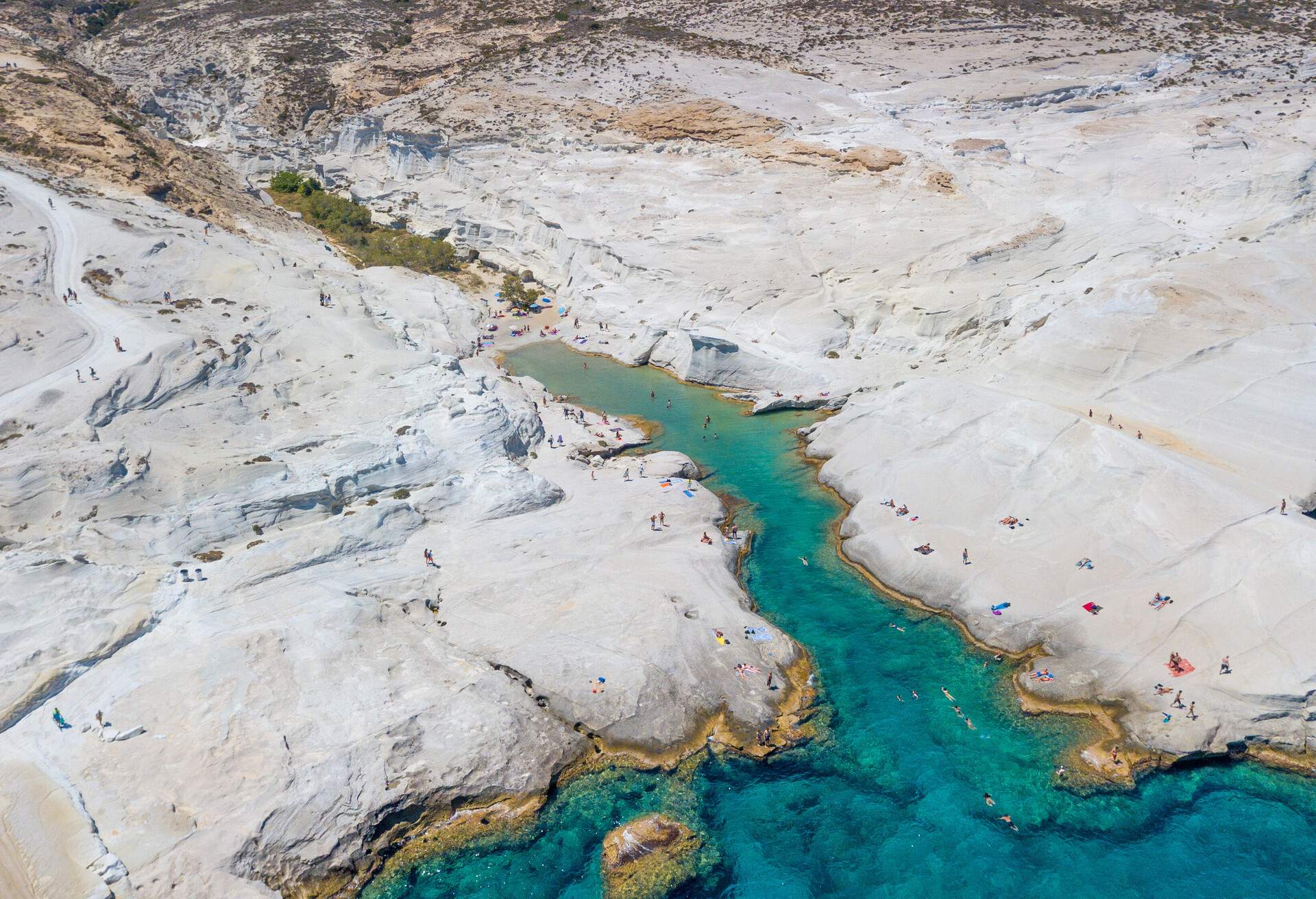 Milos island, Greece, 02 July 2018: This is an aerial picture of the famous and unique beach of Sarakiniko on Milos island. Made entirely of white rock, the landscape is unique and hundreds of visitors join every day. The beach is located on the east side of the island.