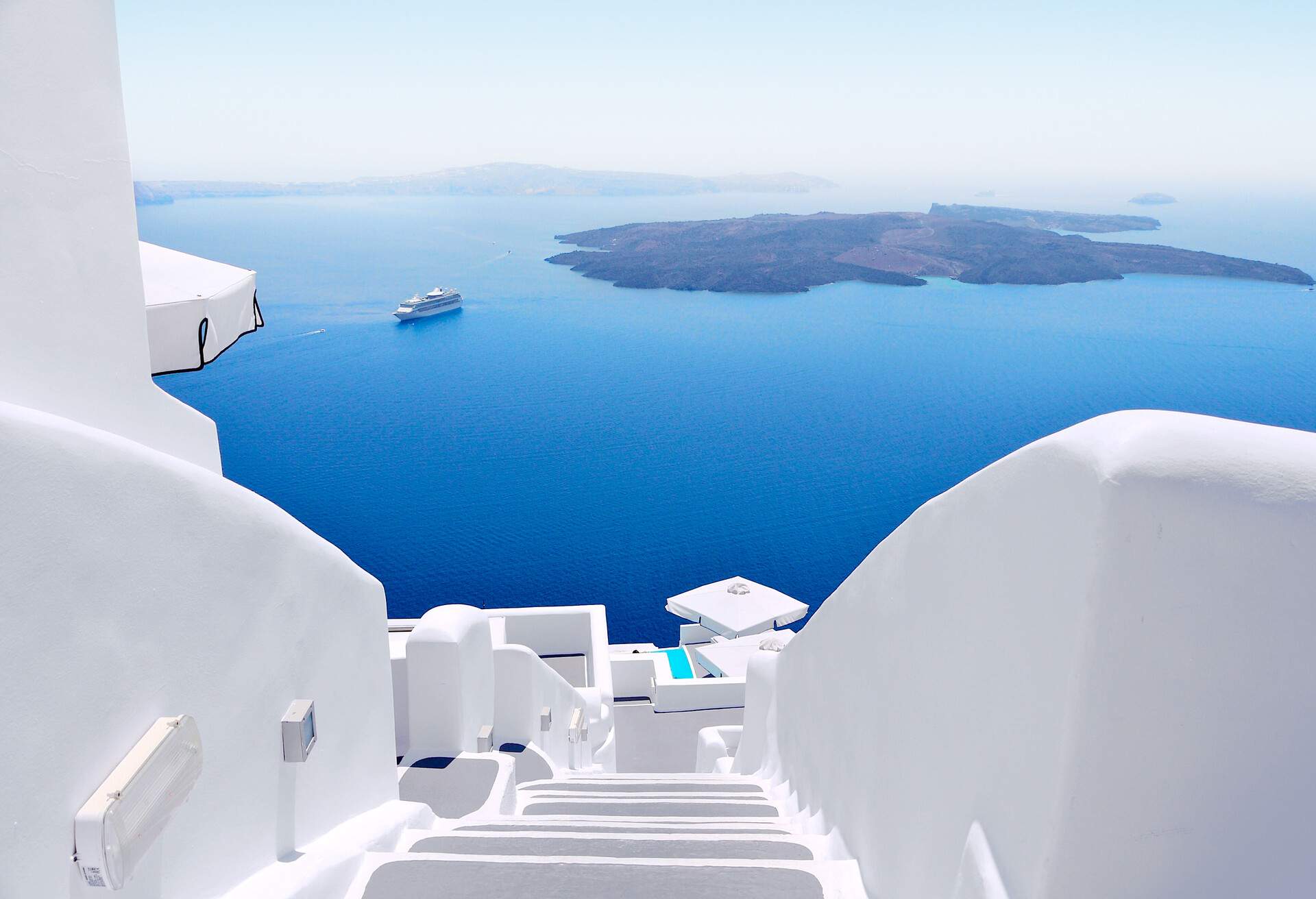 White wash staircases on Santorini Island, Greece. The view toward Caldera sea with cruise ship awaiting.