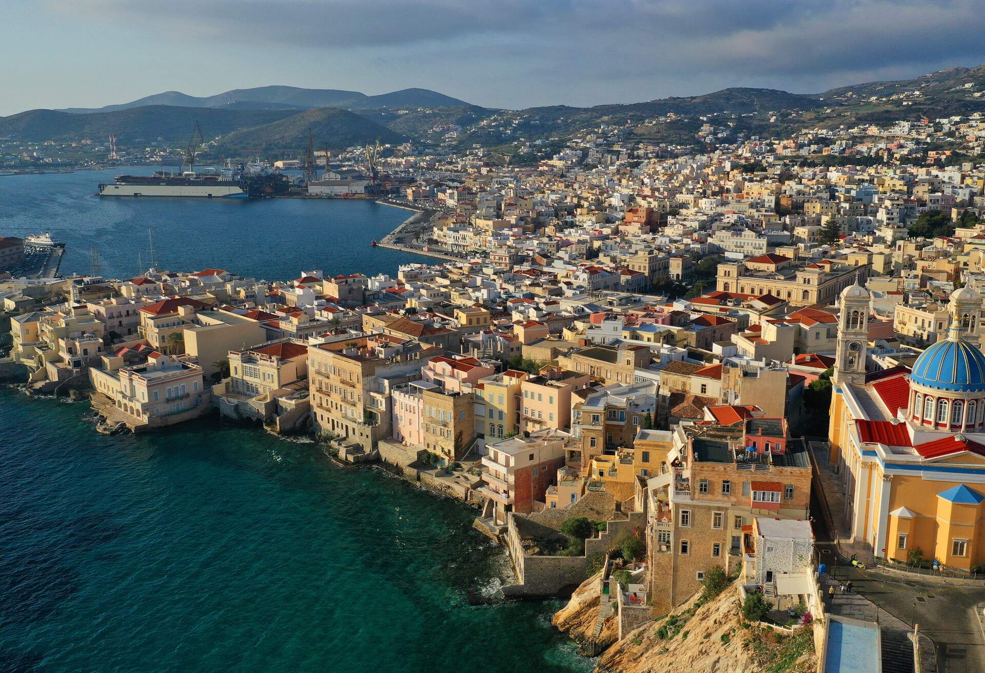 Aerial drone photo of picturesque district built by the sea of Vaporia in main town of Syros or Siros island Ermoupolis and famous church of Agios Nikolaos, Cyclades, Greece; Shutterstock ID 1573715029