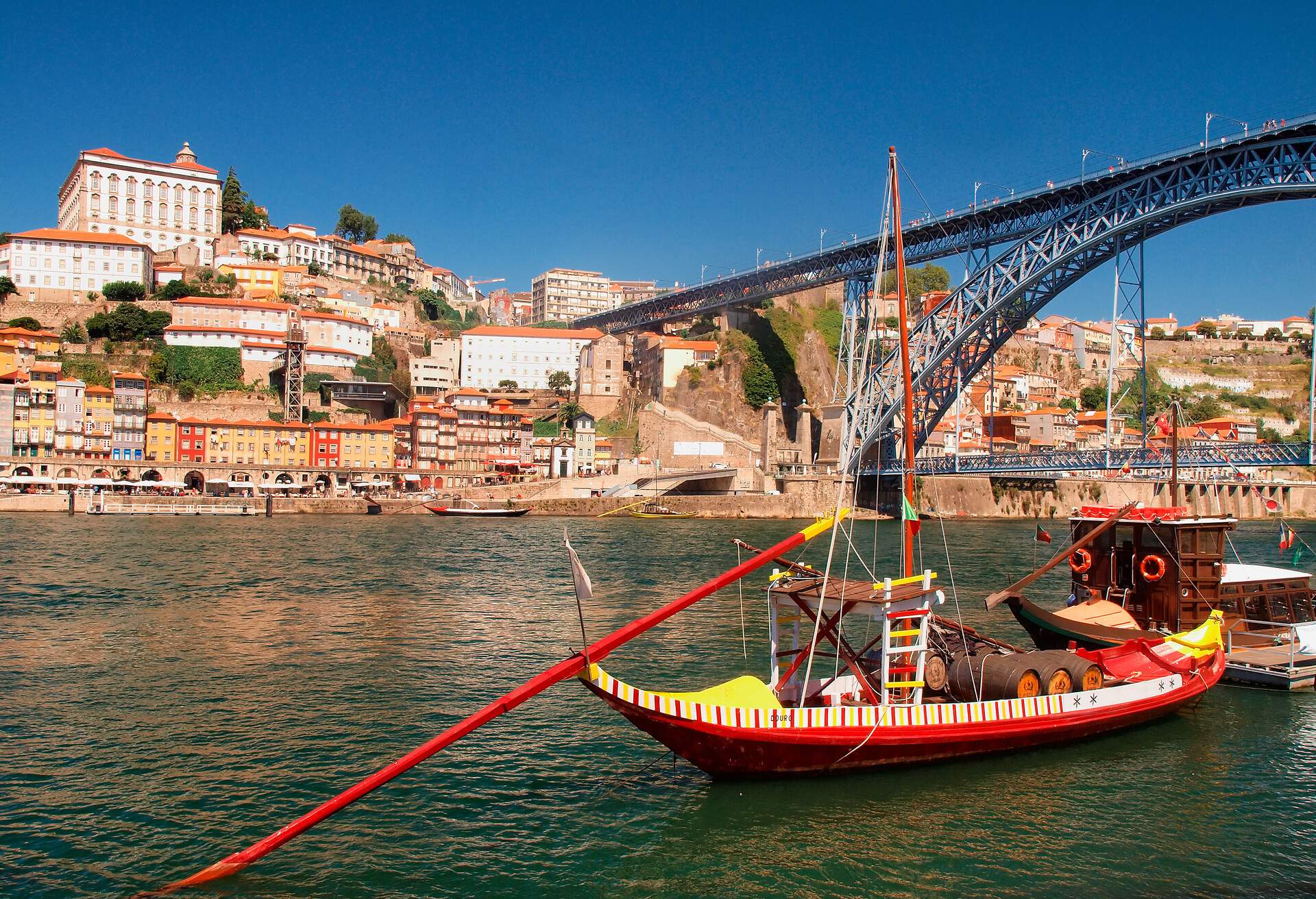 Portugal, Porto, Luiz I bridge...A view of the Luiz I bridge that links both sides of the Douro River, the cities of Porto and Vila Nova de Gaia.These boats are kmnown as Ravelos that are the old boats used to carry the Porto Wine to the wine  cellars..Located along the Douro river estuary in Northern Portugal, Porto is one of the oldest European centres, and its historical core was proclaimed a World Heritage Site by UNESCO in 1996.