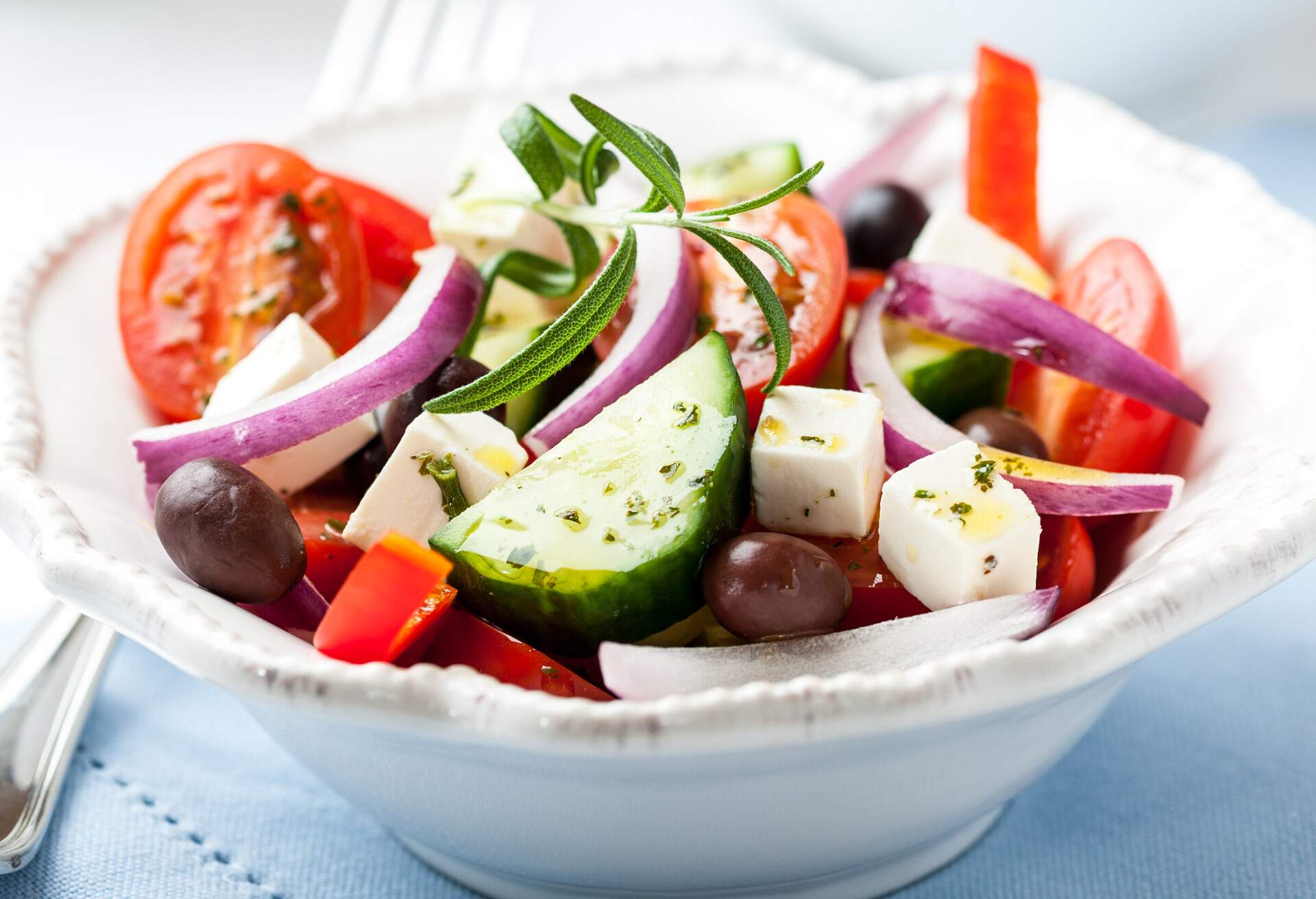 Greek salad with feta cheese, cherry tomatoes, red pepper, black and kalamata olives, cucumber, spices and fresh rosemary. Symbolic image. Concept for a tasty and healthy meal. Close .up.; Shutterstock ID 101098402; Purpose: product; Brand (KAYAK, Momondo, Any): any