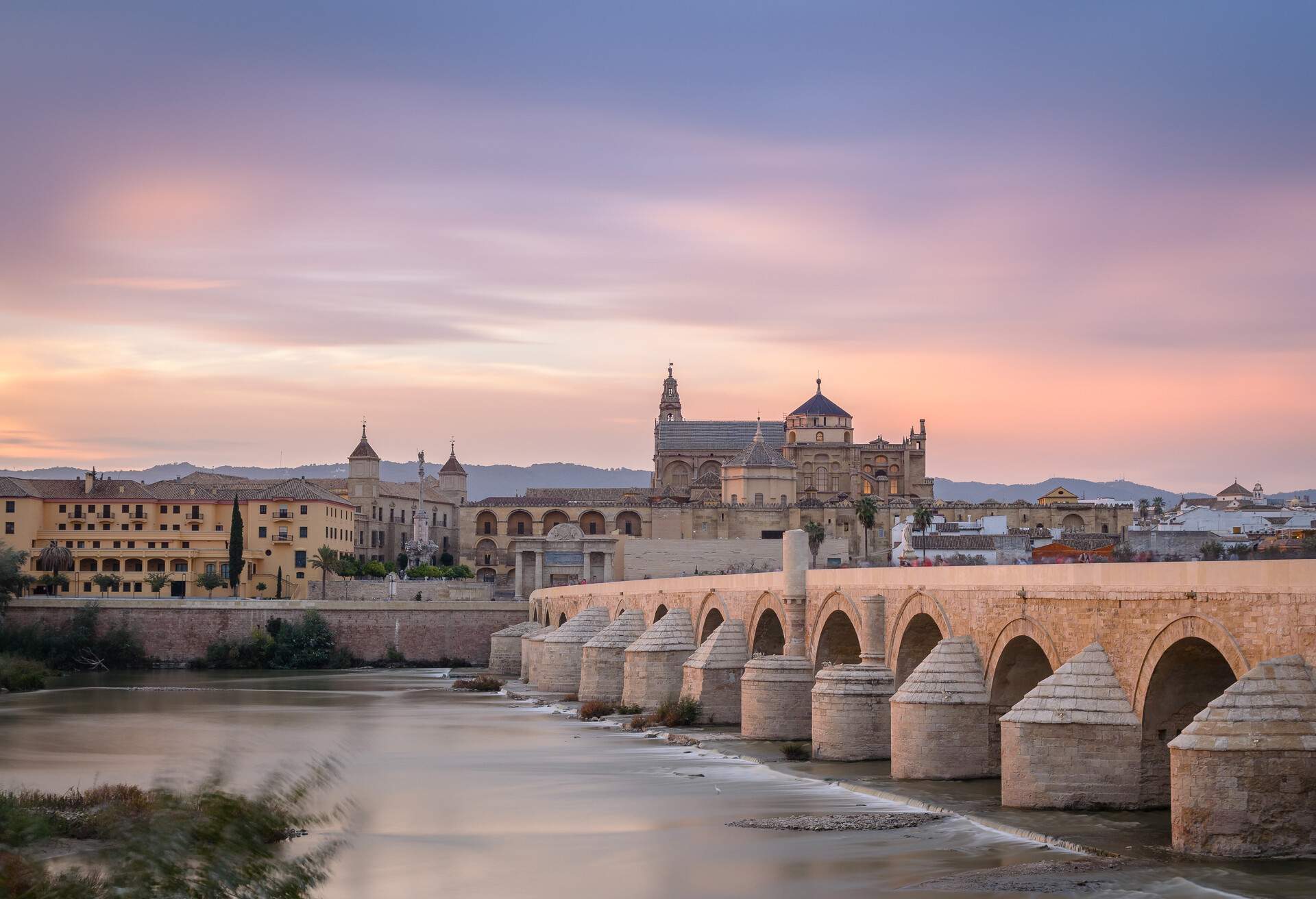 A long exposure of the sunset colours over Cordoba's Mezquita and Roman bridge.