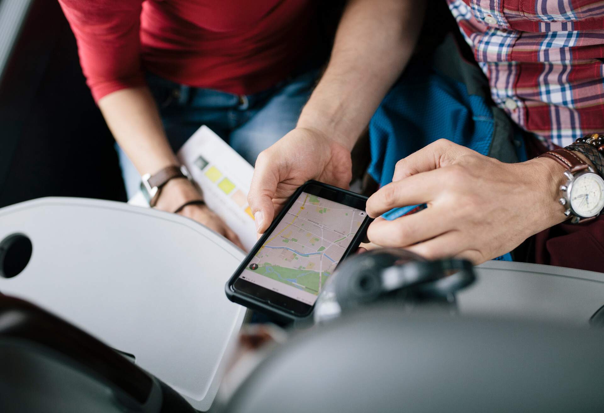 A couple travelling together on a bus are using a smartphone Map App to check their route.