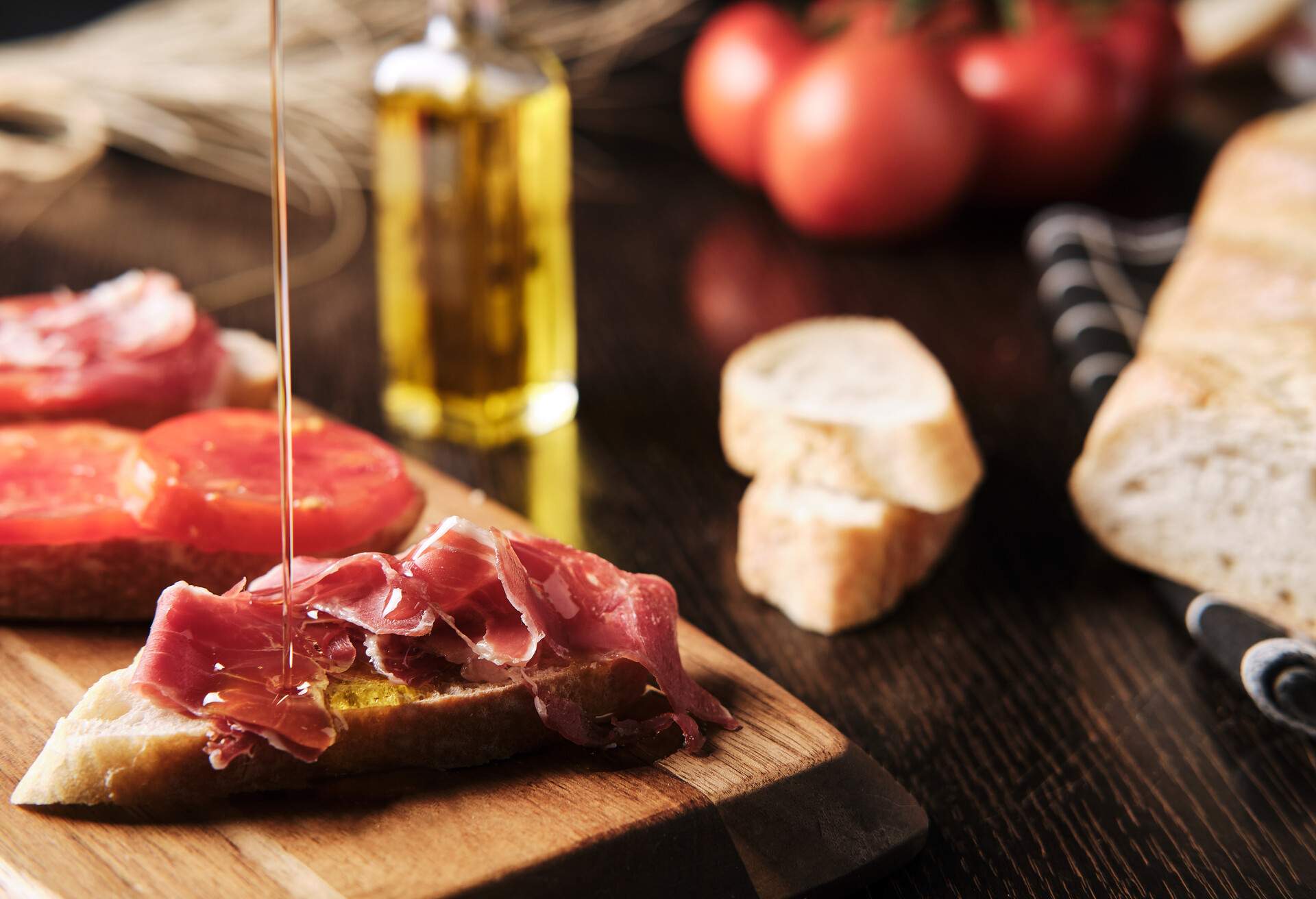 breakfast with bread, tomato, ham and oils