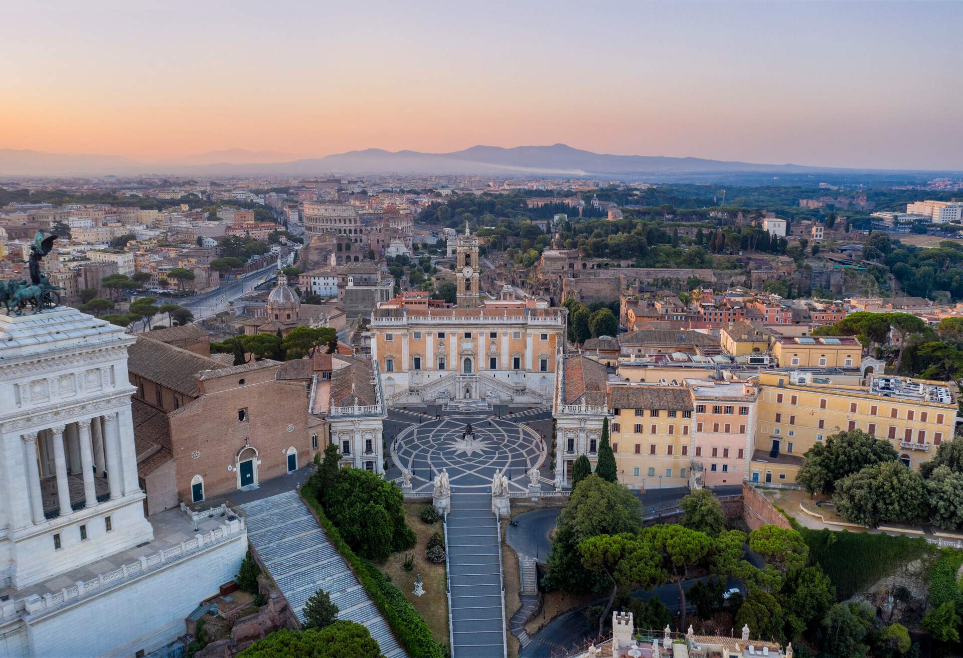 Aerial view of the Piazza del Campidoglio with Colosseum and City Buildings on background, Rome.