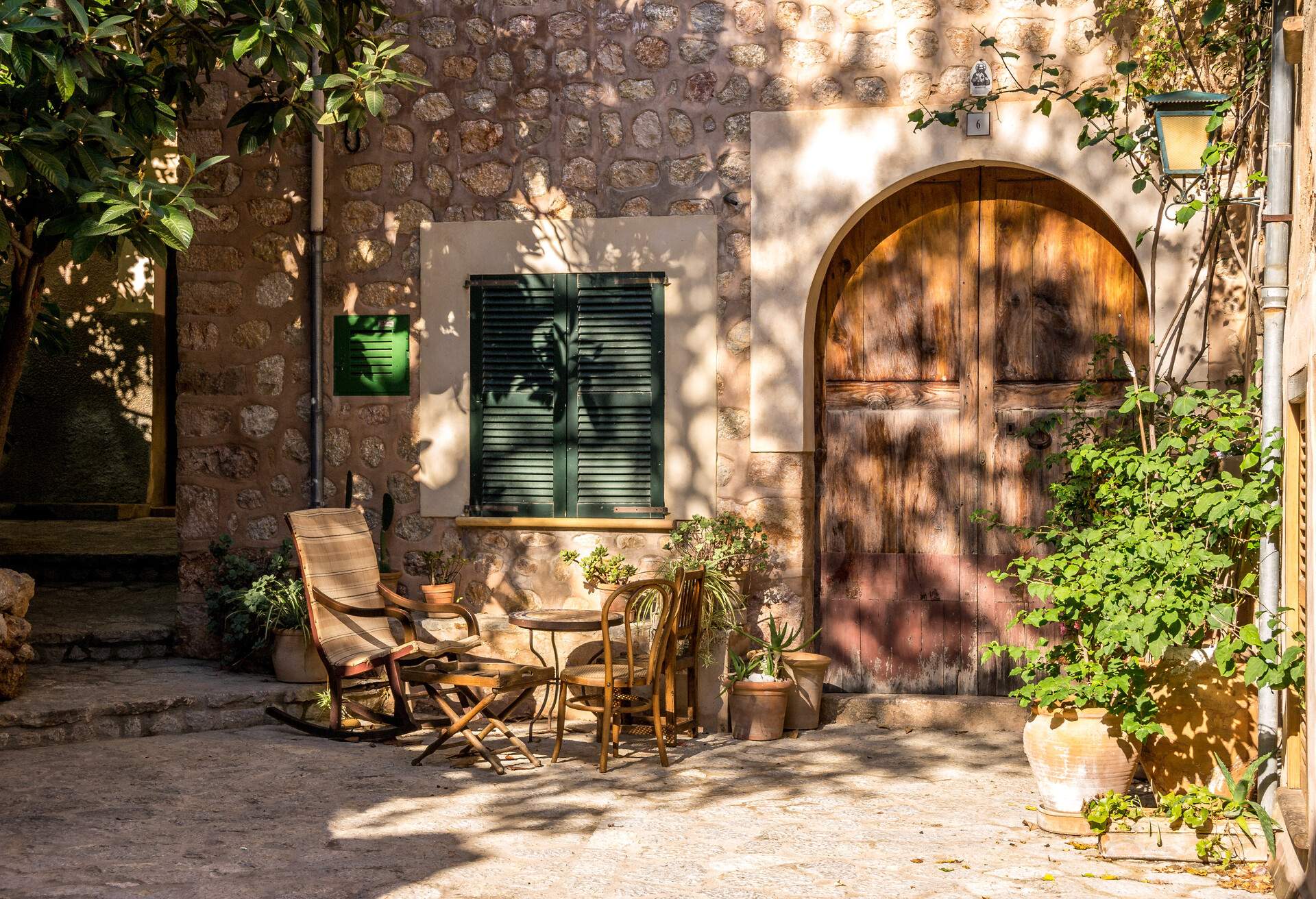 Alley with flowerpots, table and chairs in the village of Fornalutx in the northwest of the Mediterranean island of Majorca.