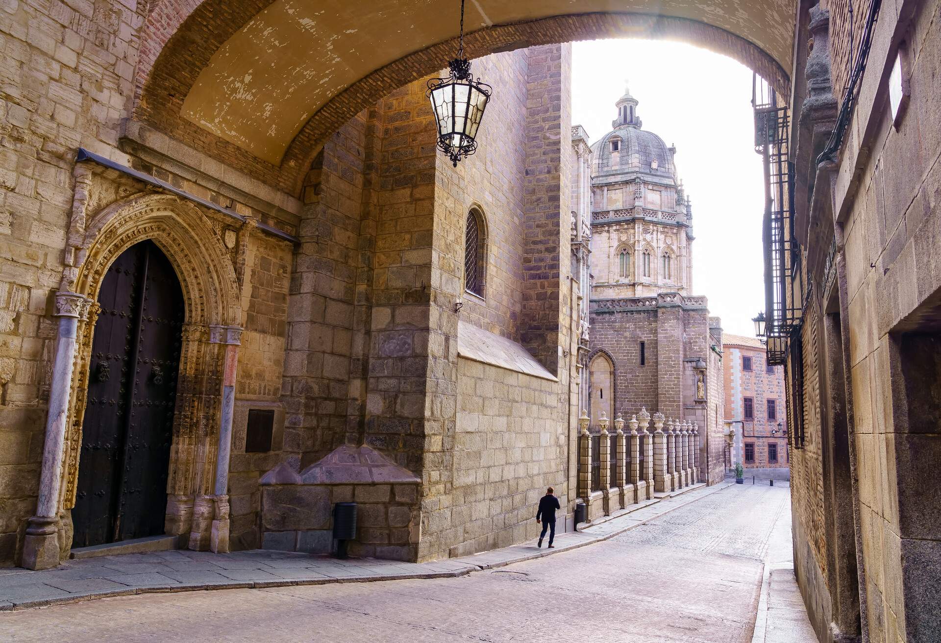 Toledo Cathedral under the stone arch of an old building in the city of Toledo Spain.