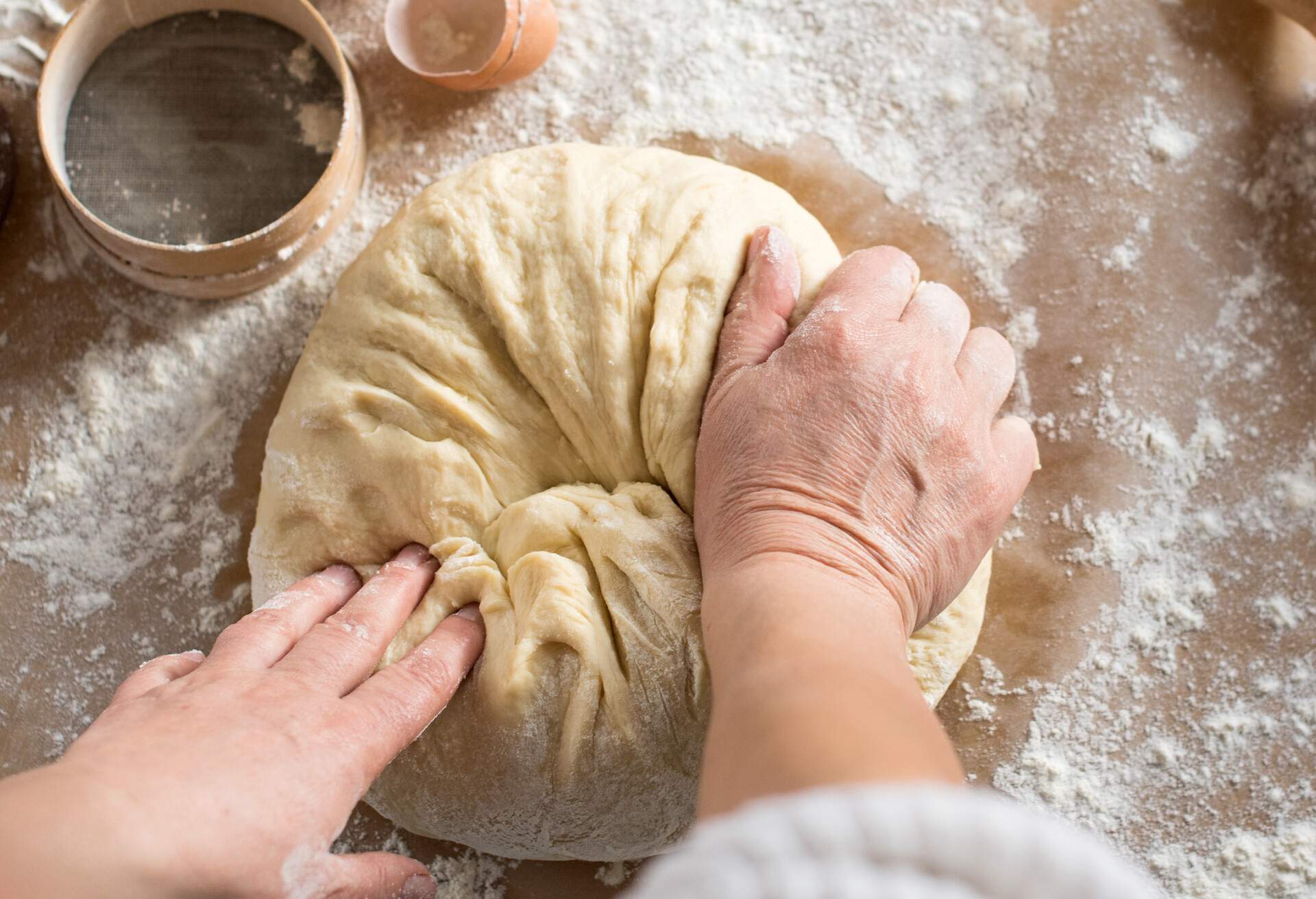 Woman kneading dough in kitchen