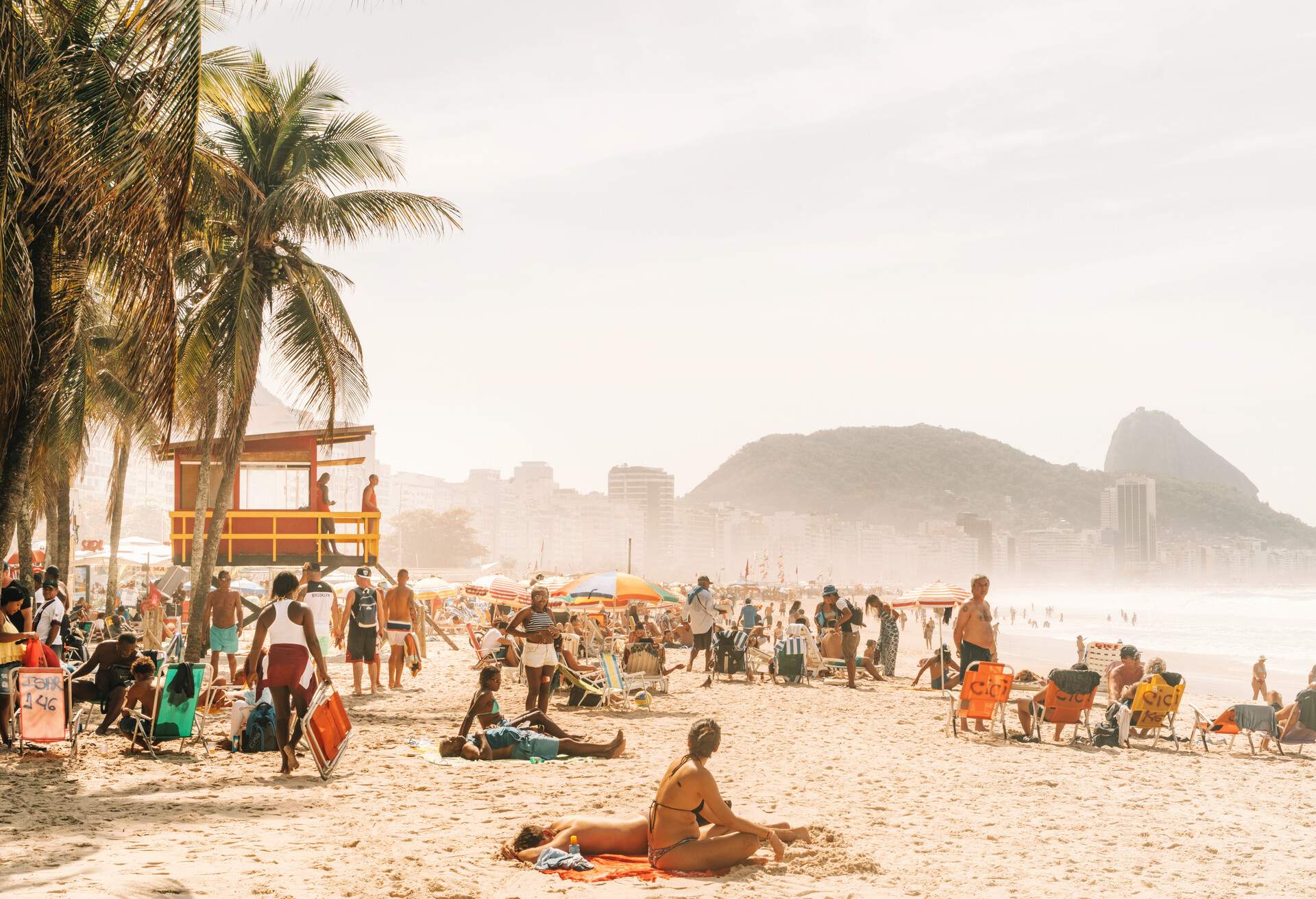 people relaxing and sunbathing at famous Copacabana beach, Rio de Janeiro, Brazil