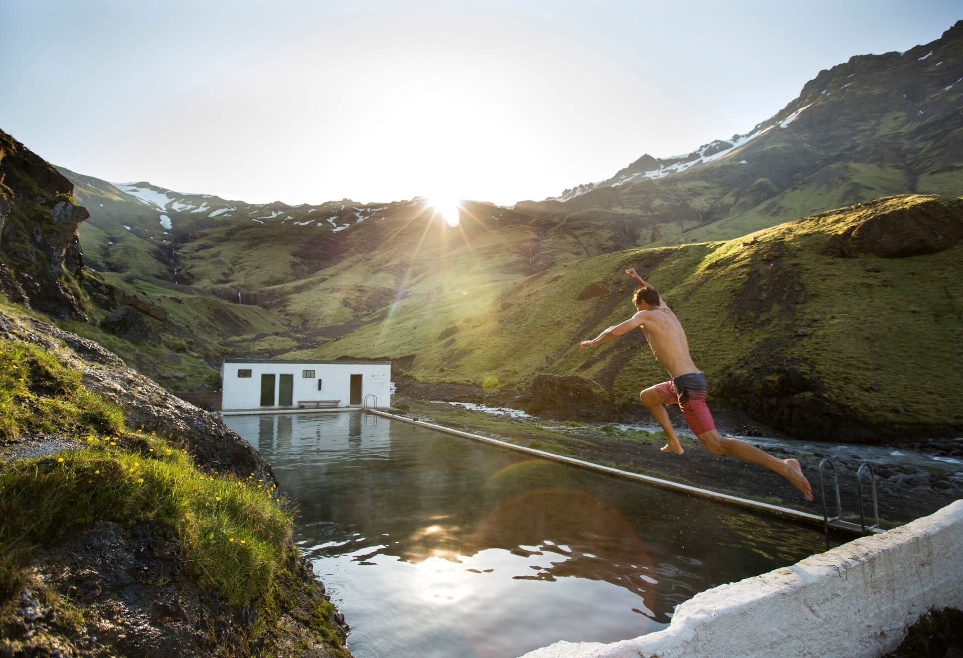 A man jumping into a hot spring in Iceland.