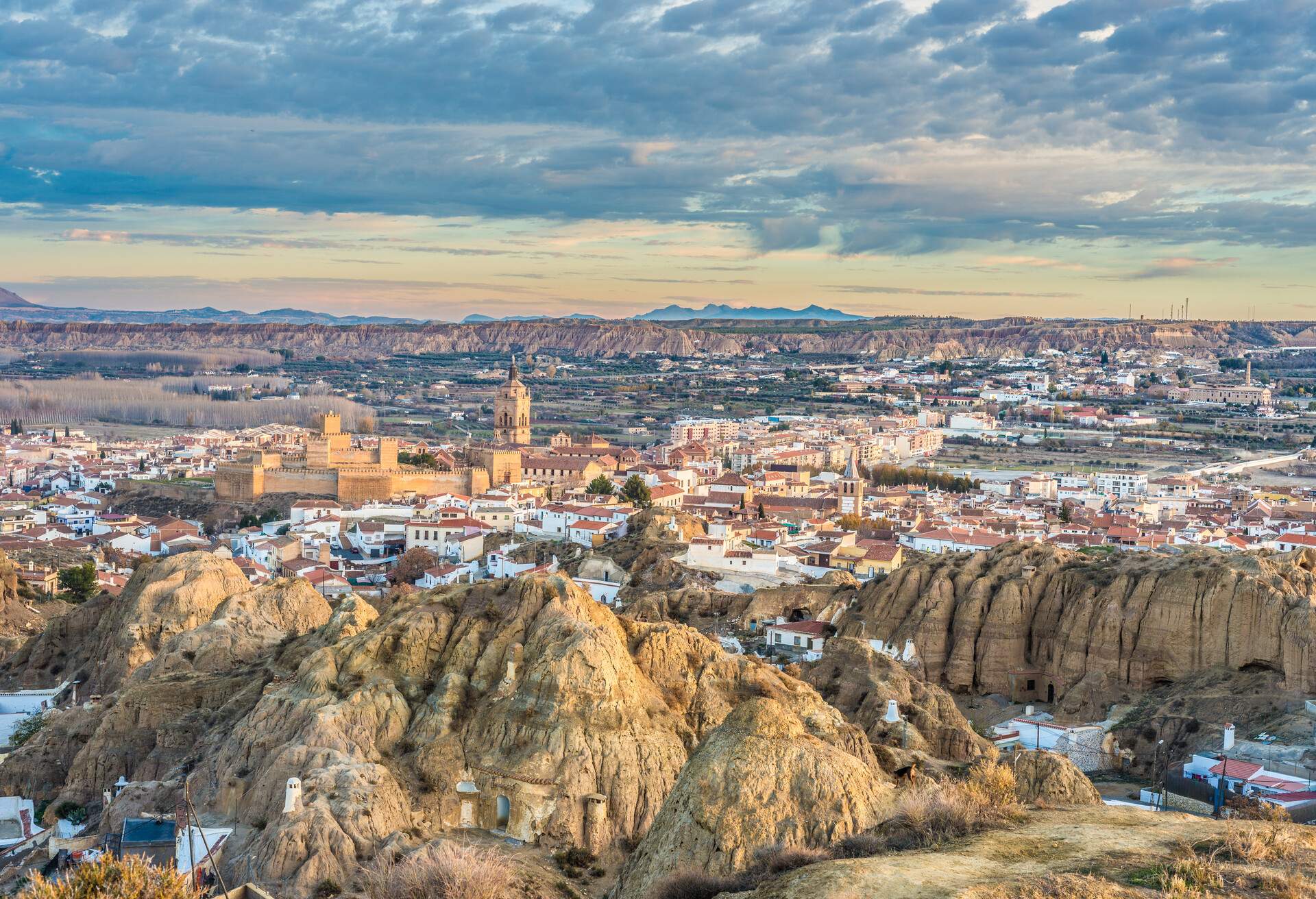 Skyline of Guadix, Spain with cave dwellings, castle, cathedral and colourful houses.