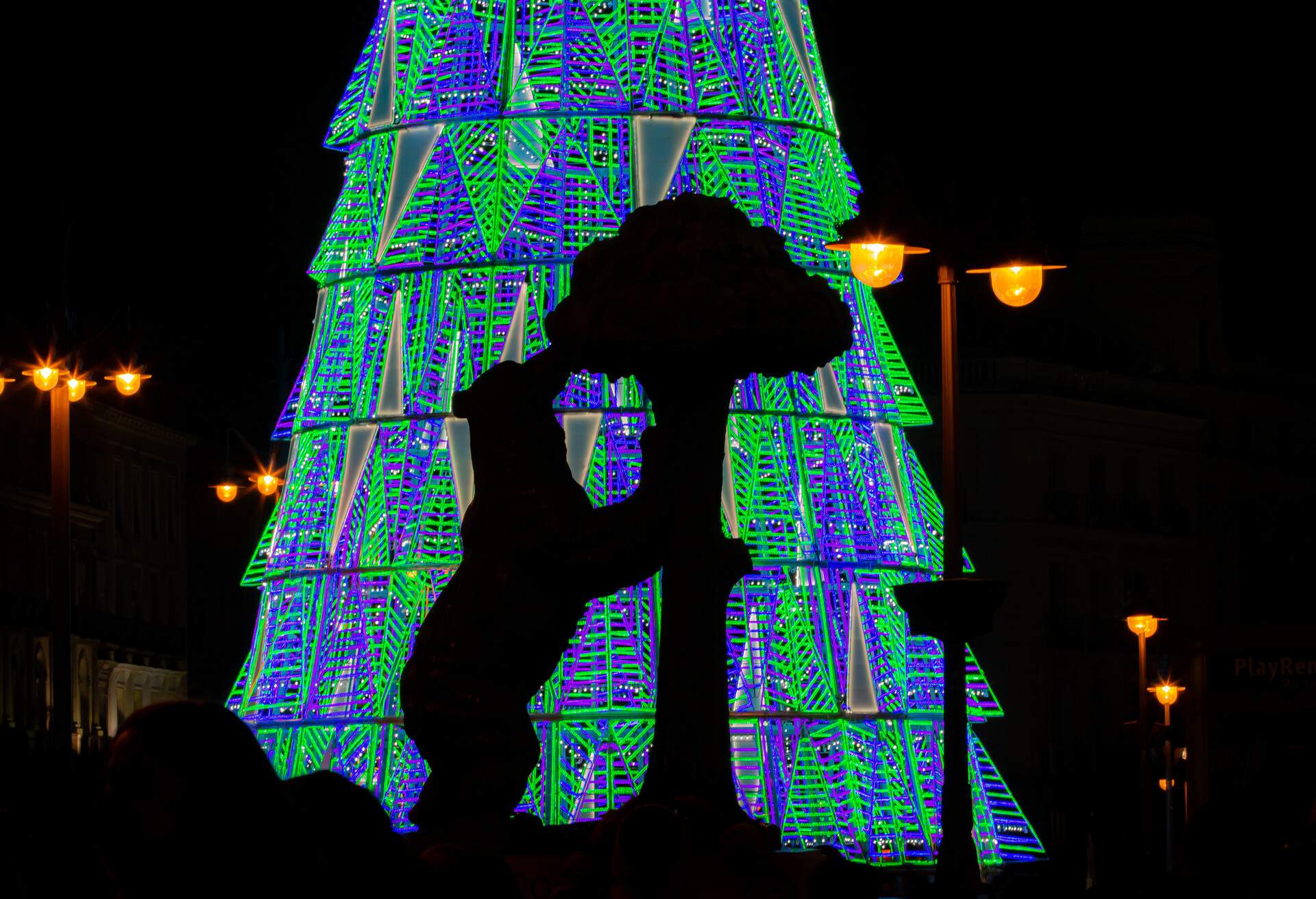Madrid, Spain; 11 28 2020. Silhouette of the sculpture by the contrast with the Christmas tree in the background at Puerta del Sol.