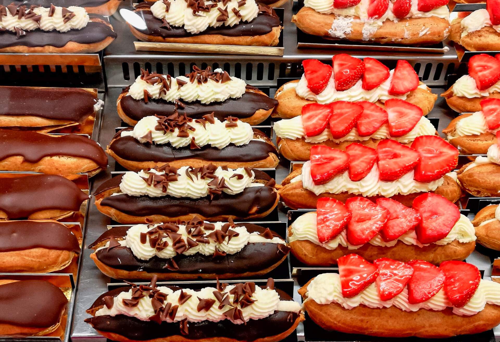 Delicious éclairs with strawberry and sugar icing, lined up in order, perfect coffee treat for self reward and indulgence