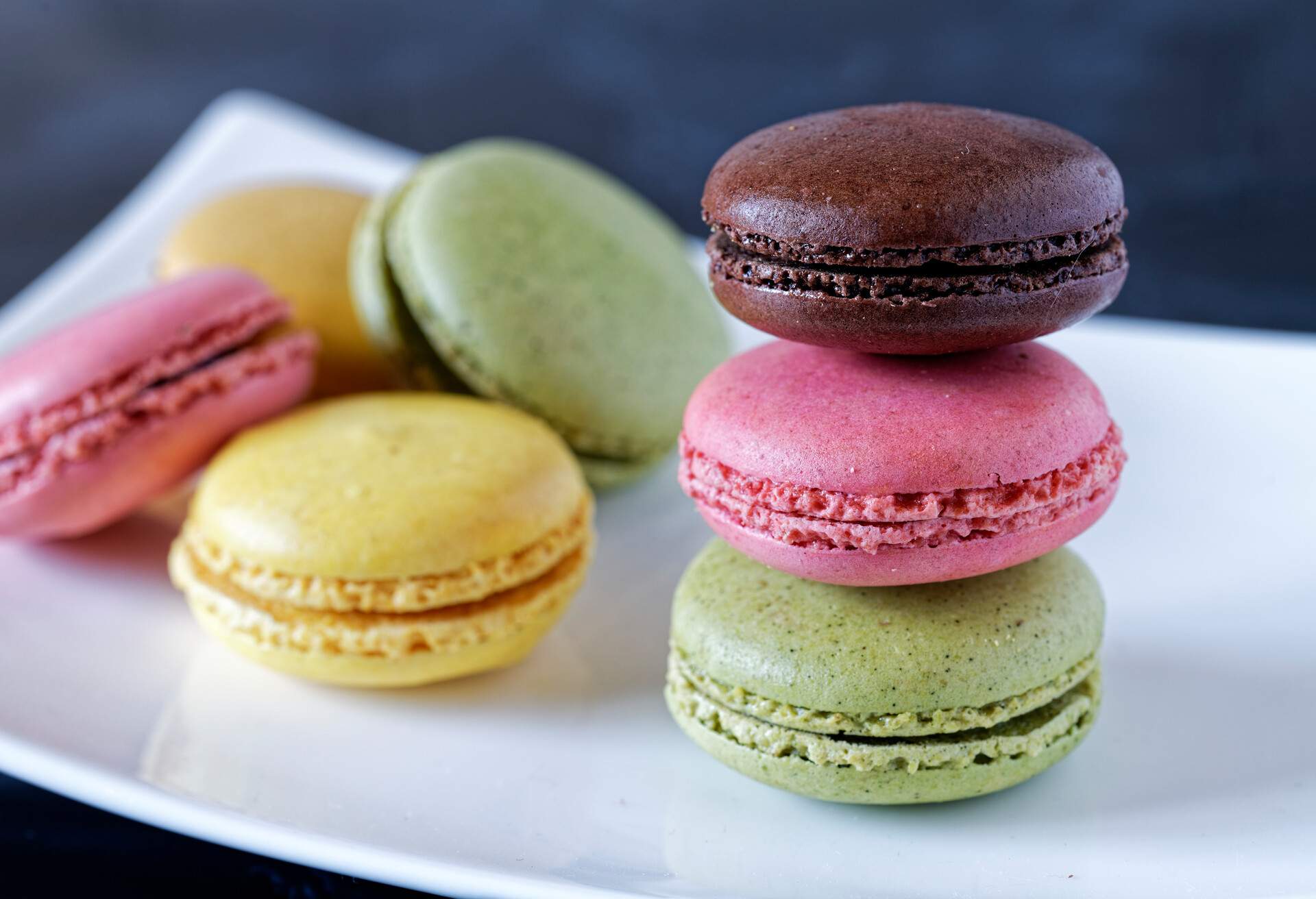 Colorful French macarons stacked on white plate