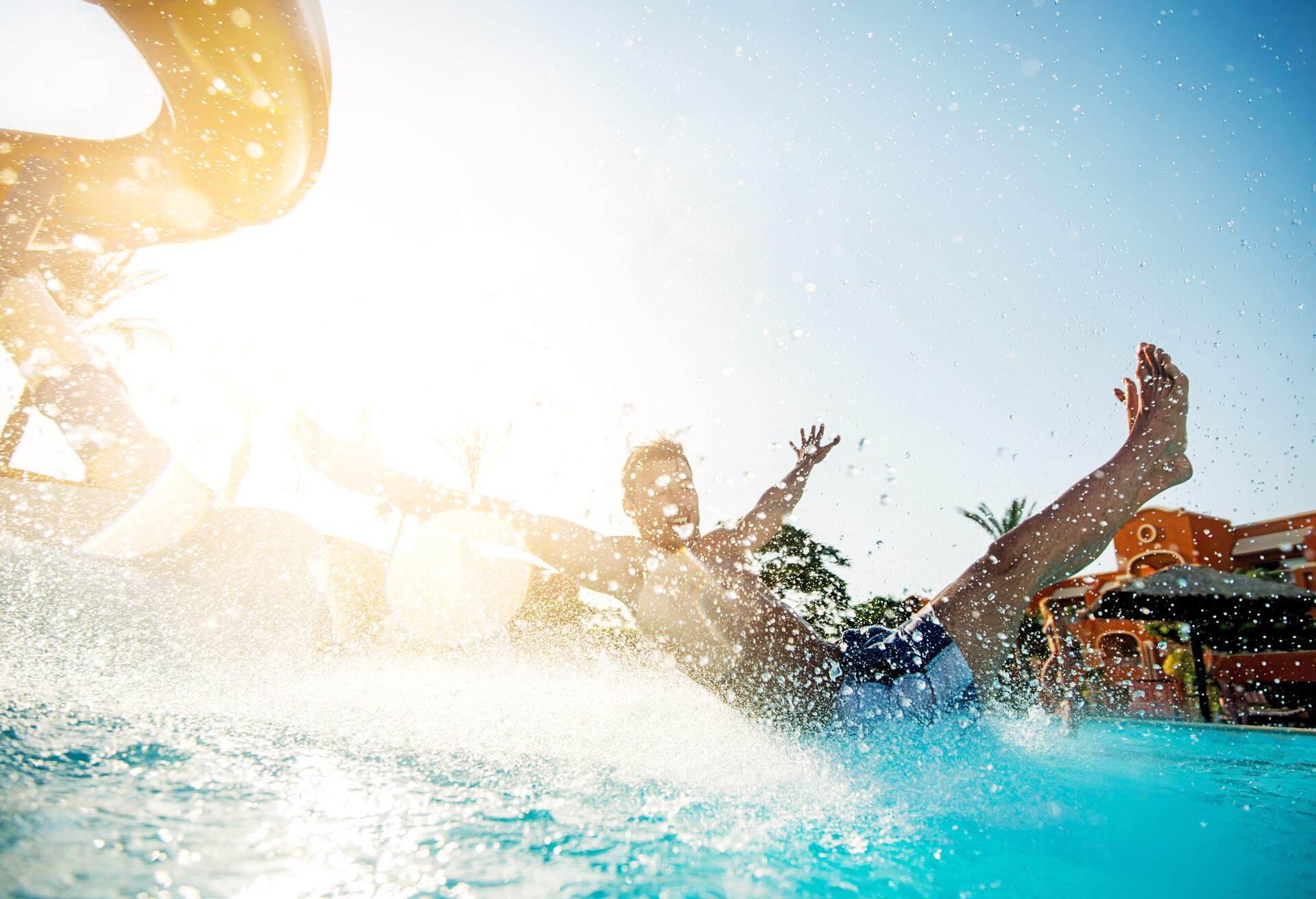 Cheerful young man enjoying in water park during summer day.