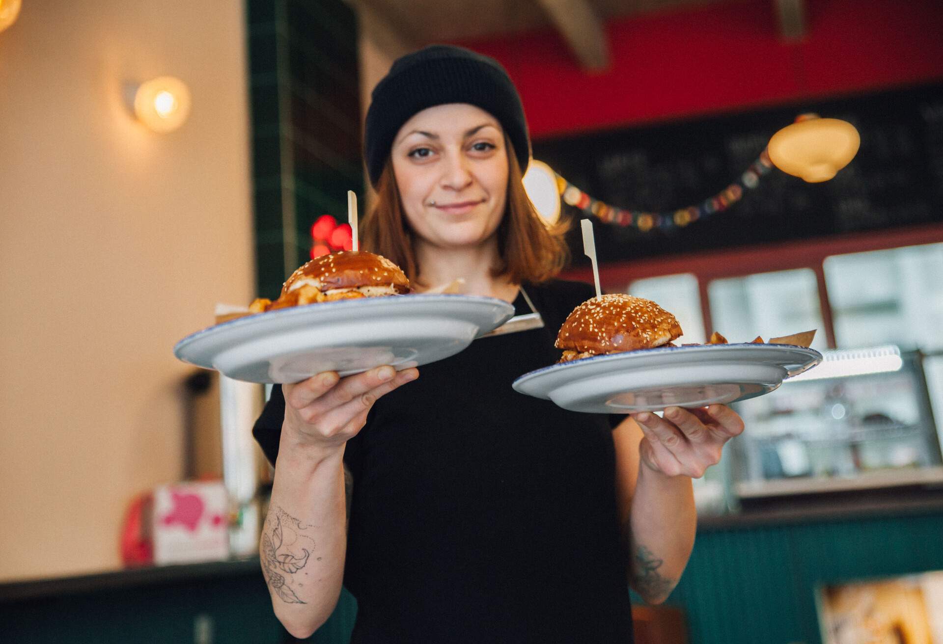 THEME_PEOPLE_WOMAN_BURGER_RESTAURANT_GettyImages-1248958242