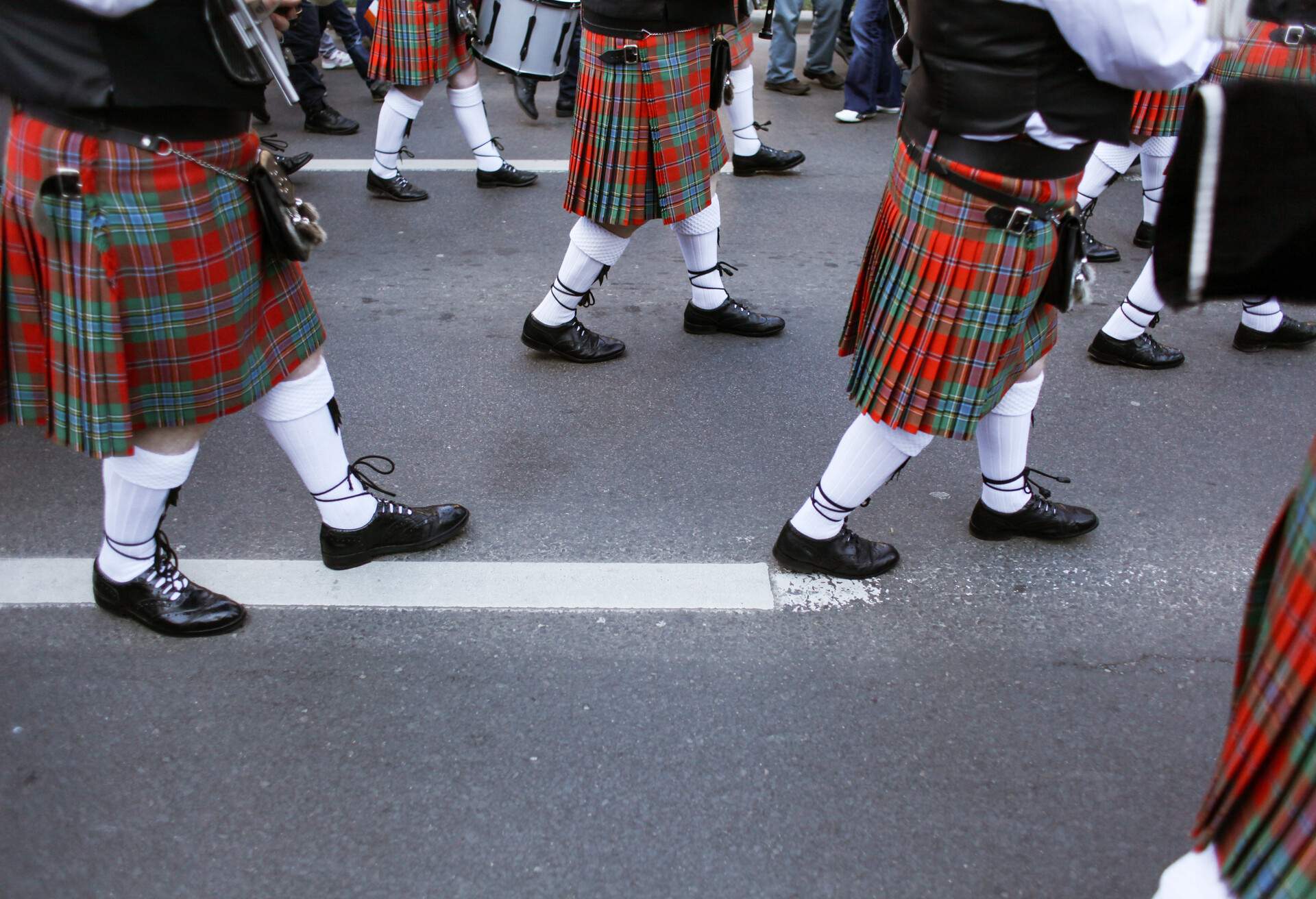 Men dressed in Irish traditional kilts march on the streets during St Patrick's Day.