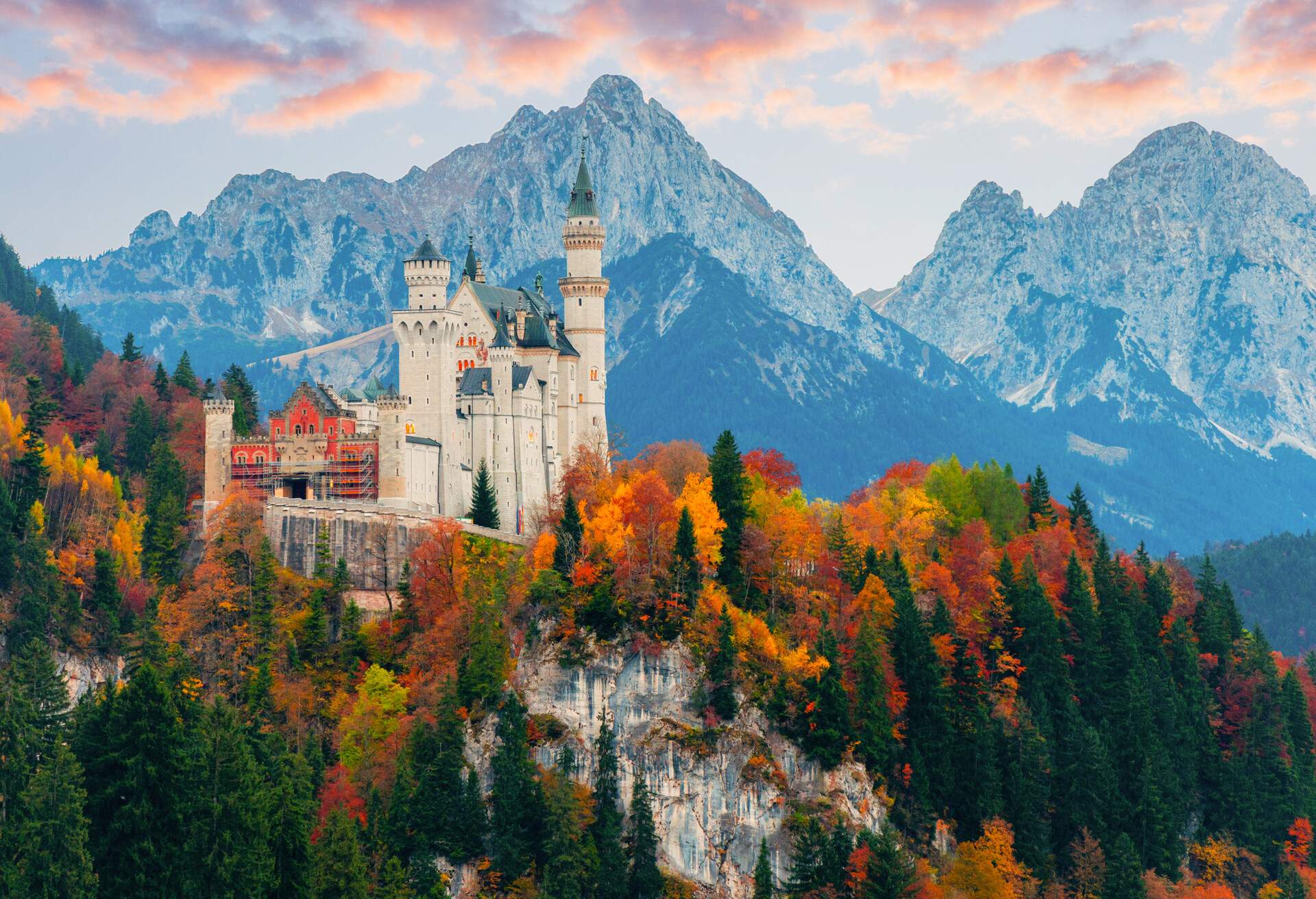 Picturesque autumn view on Neuschwanstein Castle with colorful trees and the Alps on background, Bavaria, Germany.