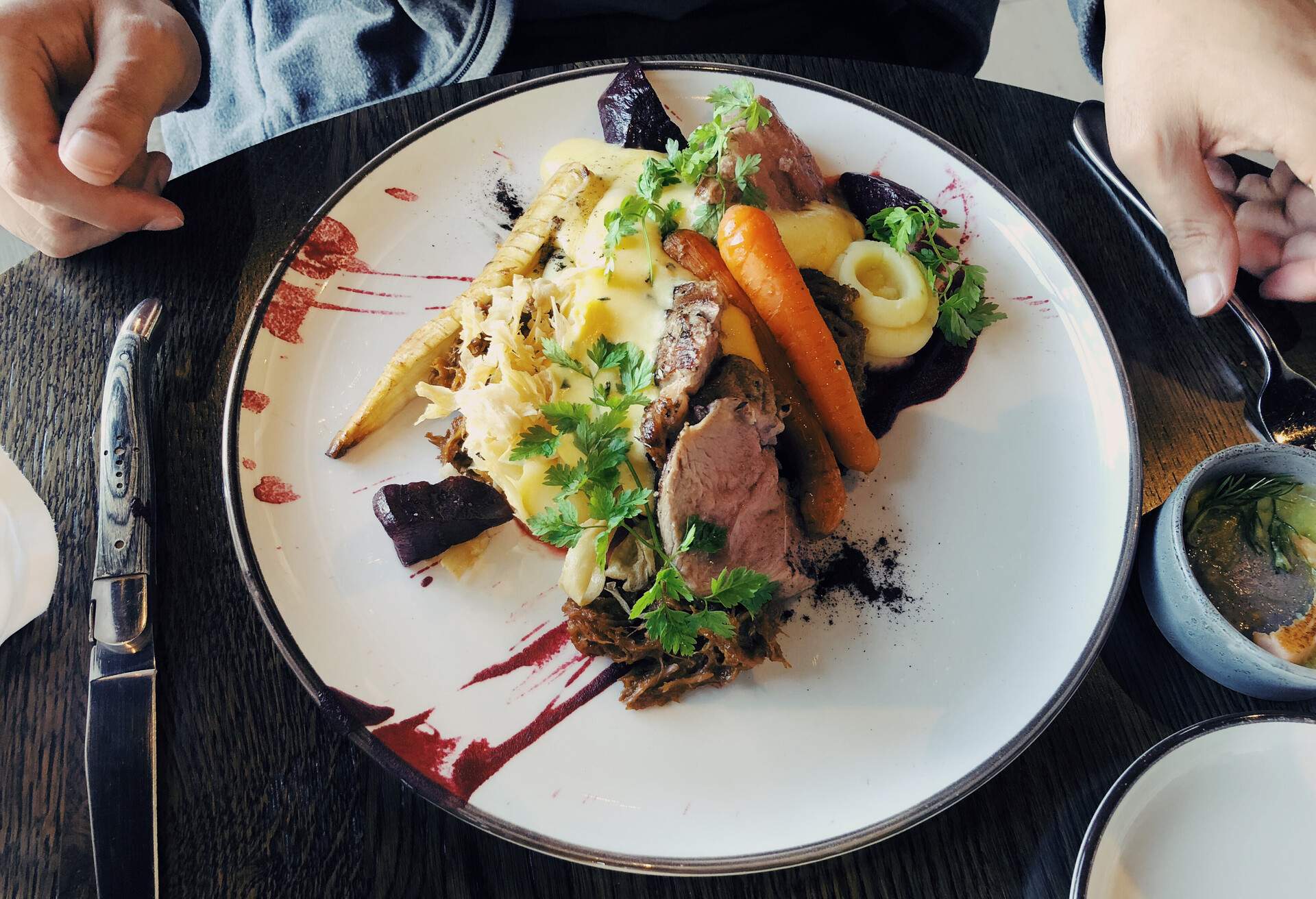 Man eating Icelandic dish: cooked lamb steak served with vegetables and mashed potatoes