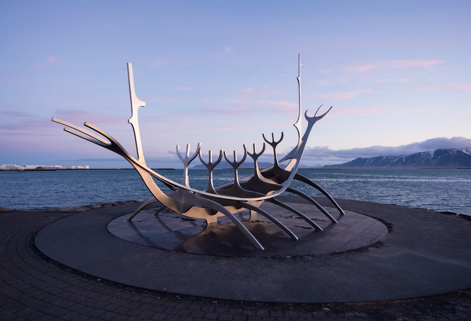 the monument at reykjavik bay have the fog on the mountain at background