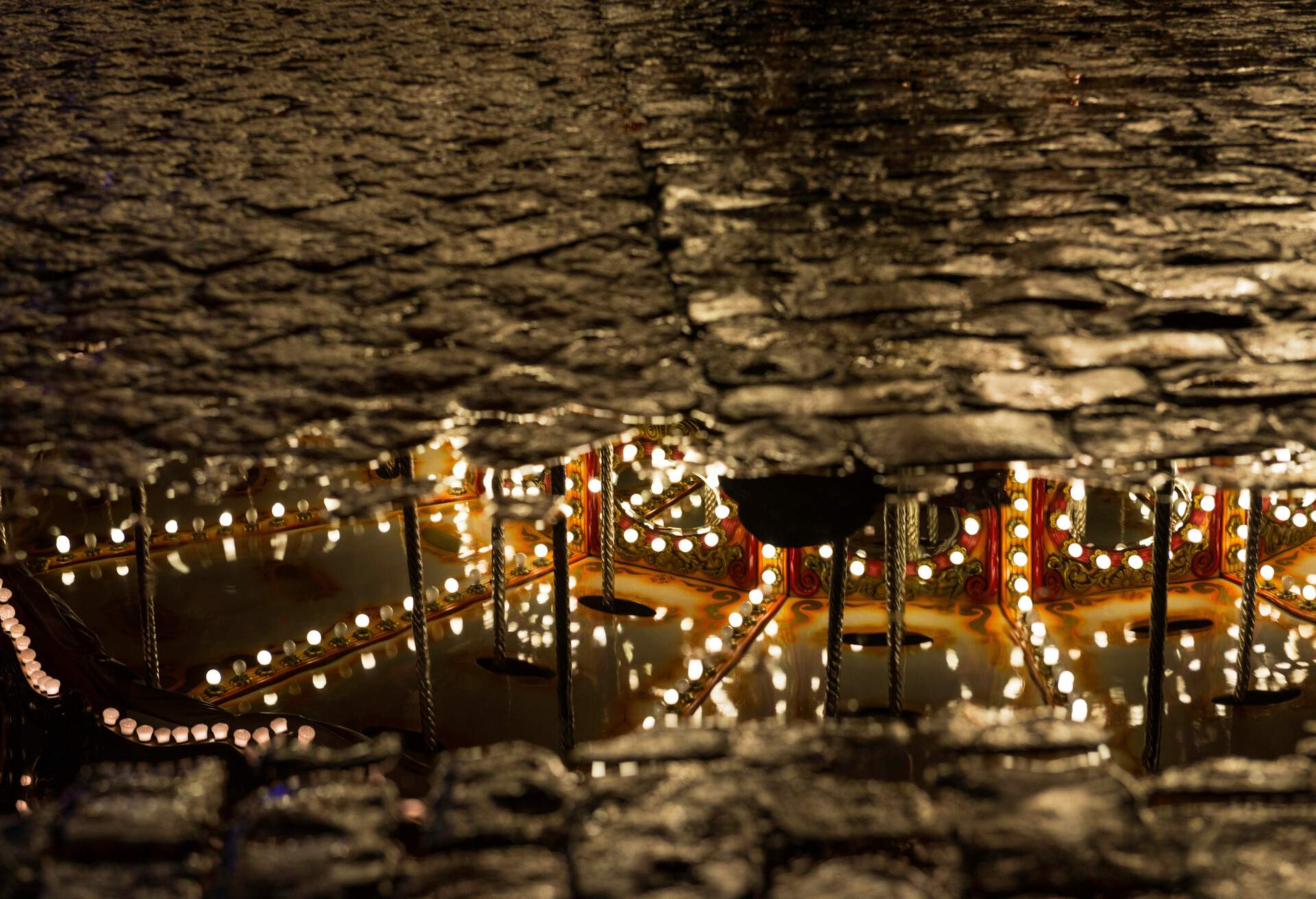 Christmas carousel reflected on a puddle at the Plaza Mayor in Madrid, Spain.