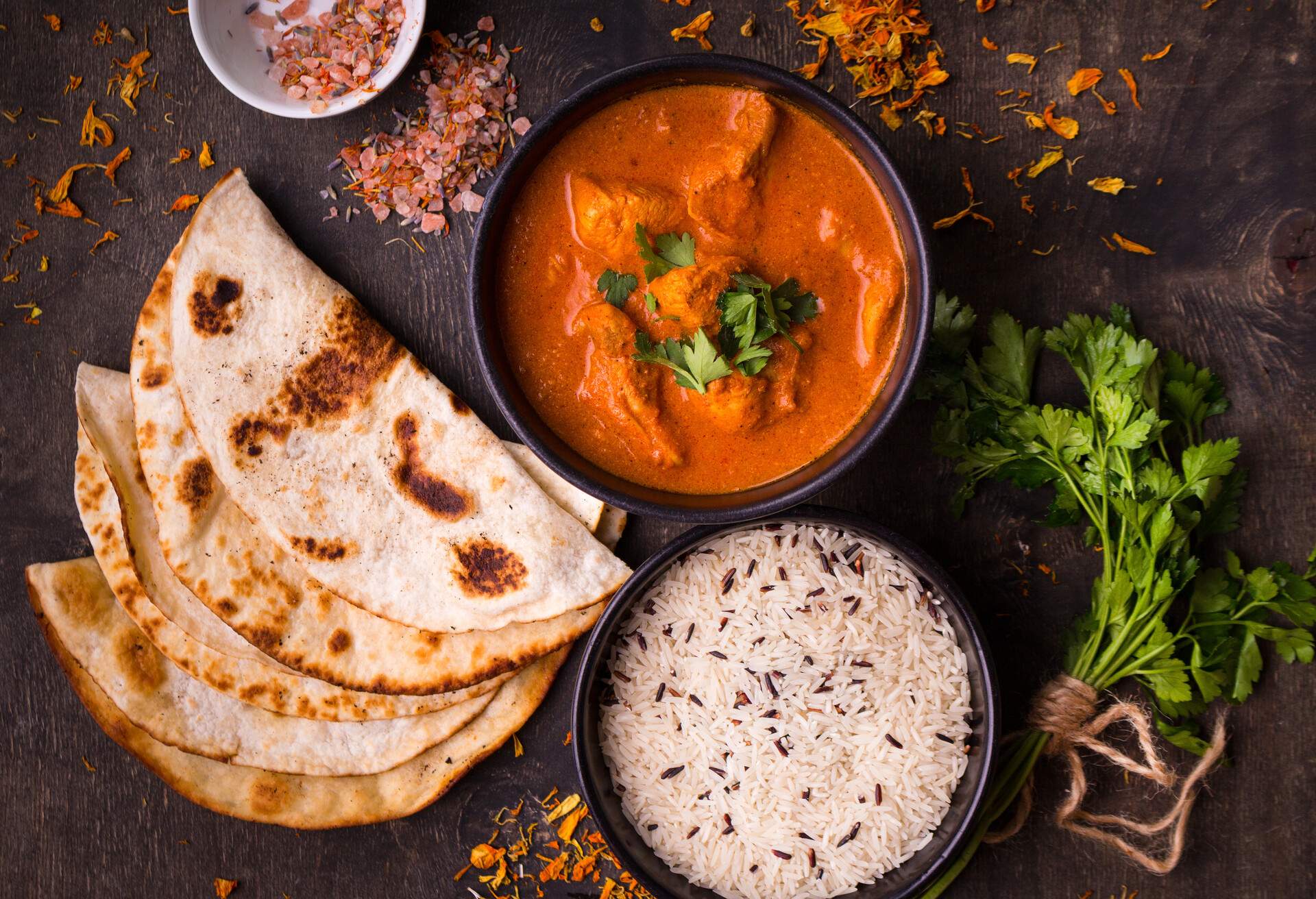 Hot spicy chicken tikka masala in bowl. Chicken curry with rice, indian naan butter bread, spices, herbs. Traditional Indian/British dish, popular indian curry in UK. Top view. Indian food. Close-up ; Shutterstock ID 594029894; Purpose: Campaign Ad; Brand (KAYAK, Momondo, Any): OpenTable