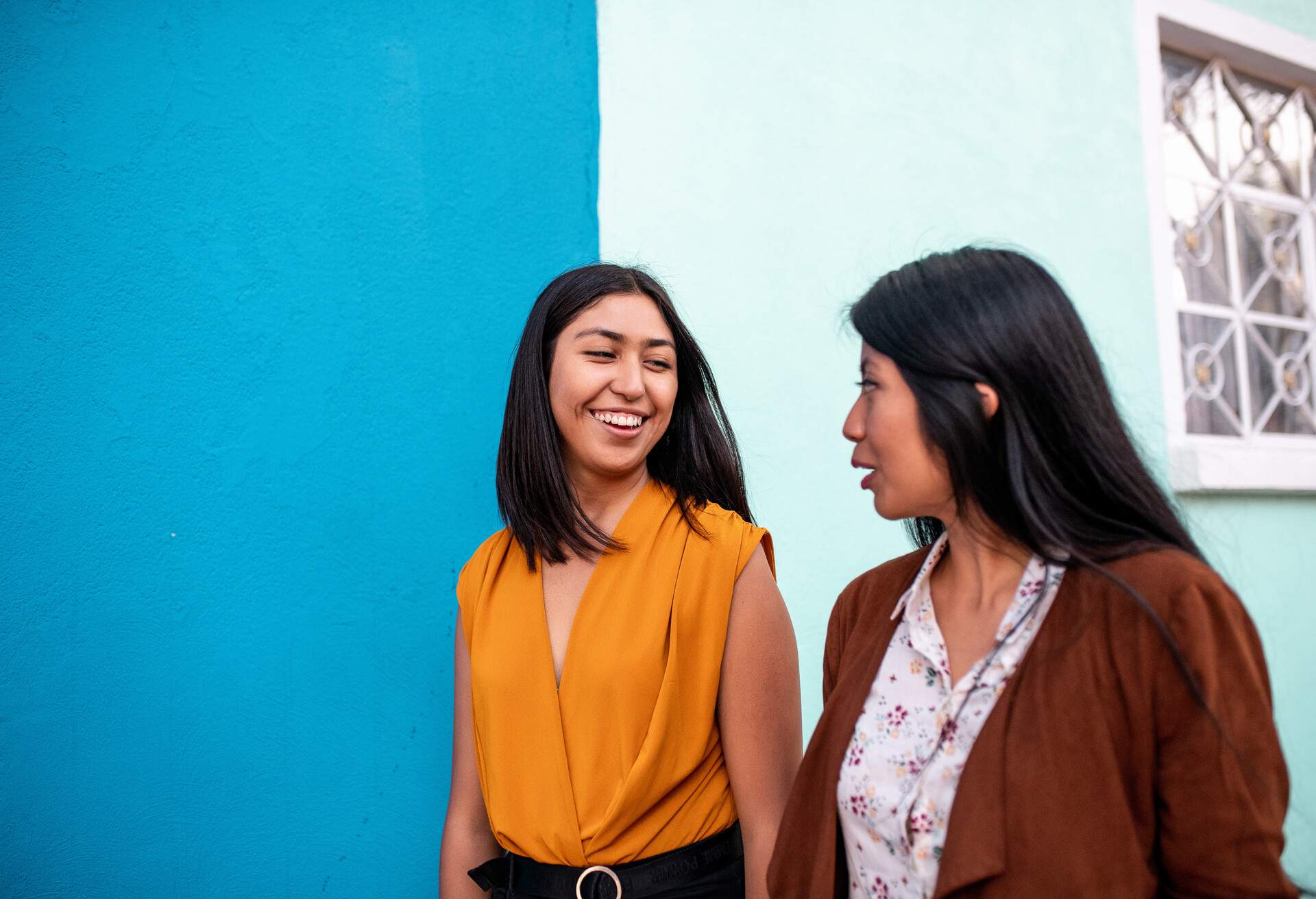 Two friends walking down the city street and talking