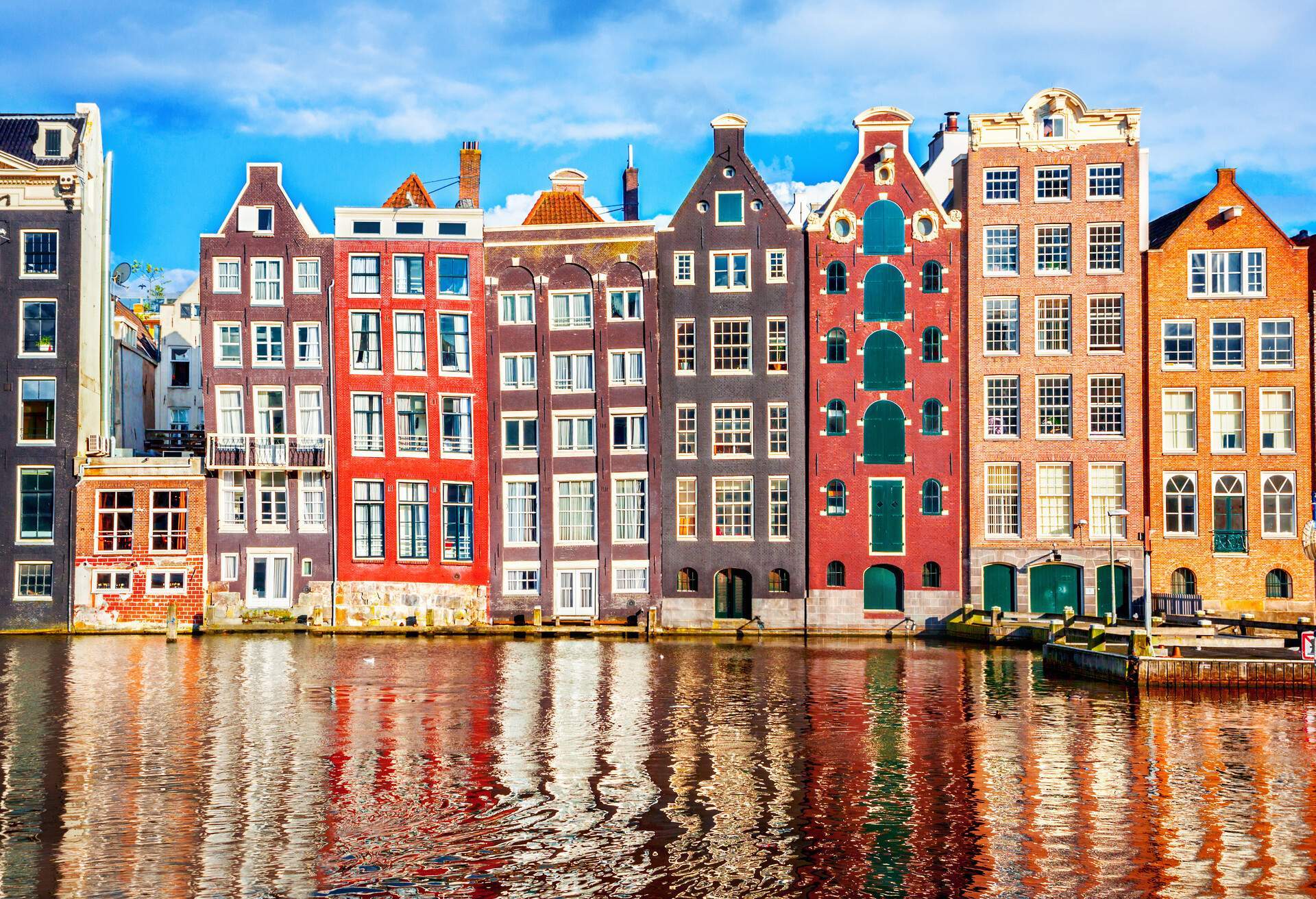 Colourful and skewed houses along the edge of a canal.