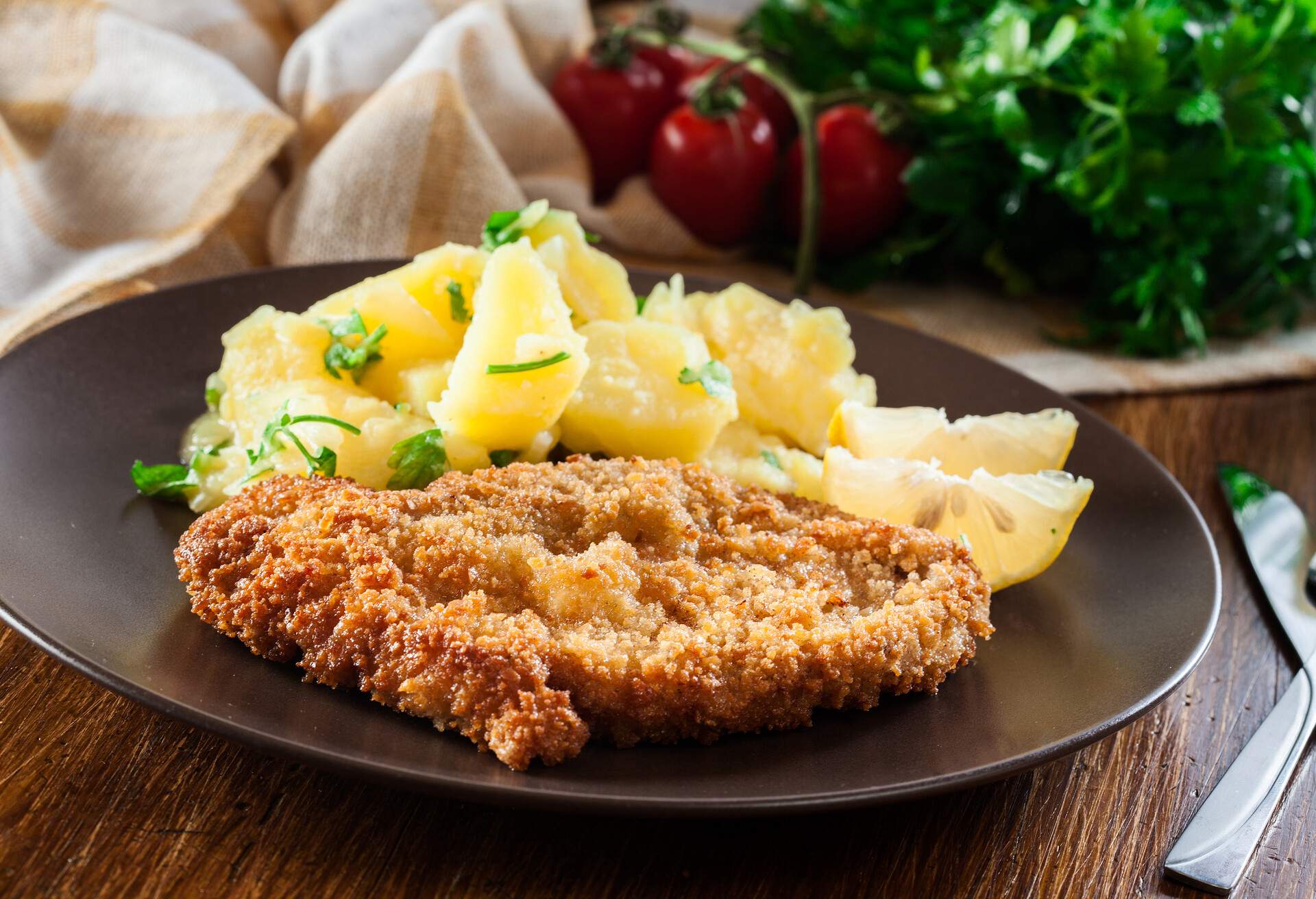 Homemade breaded viennese schnitzel with potato salad on a plate