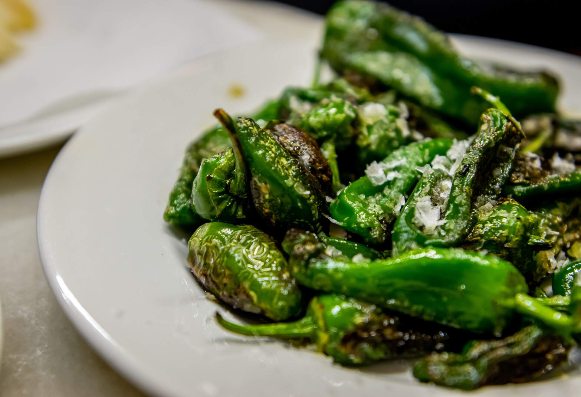 Padrón peppers with sea salt on a plate in a small restaurant of Barcelona. 