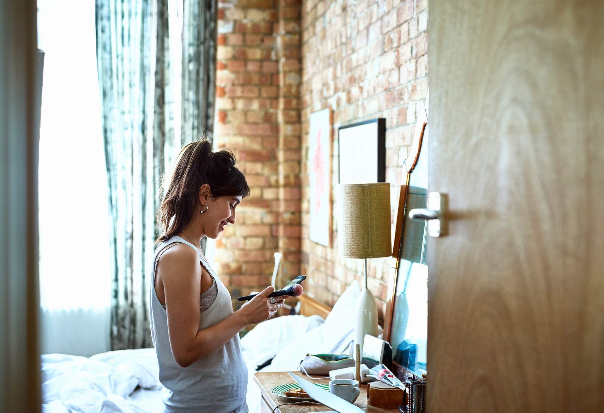 THEME_HOTEL_PEOPLE_WOMAN_LOOKING-AT-PHONE_DEVICE_GettyImages-1006503826