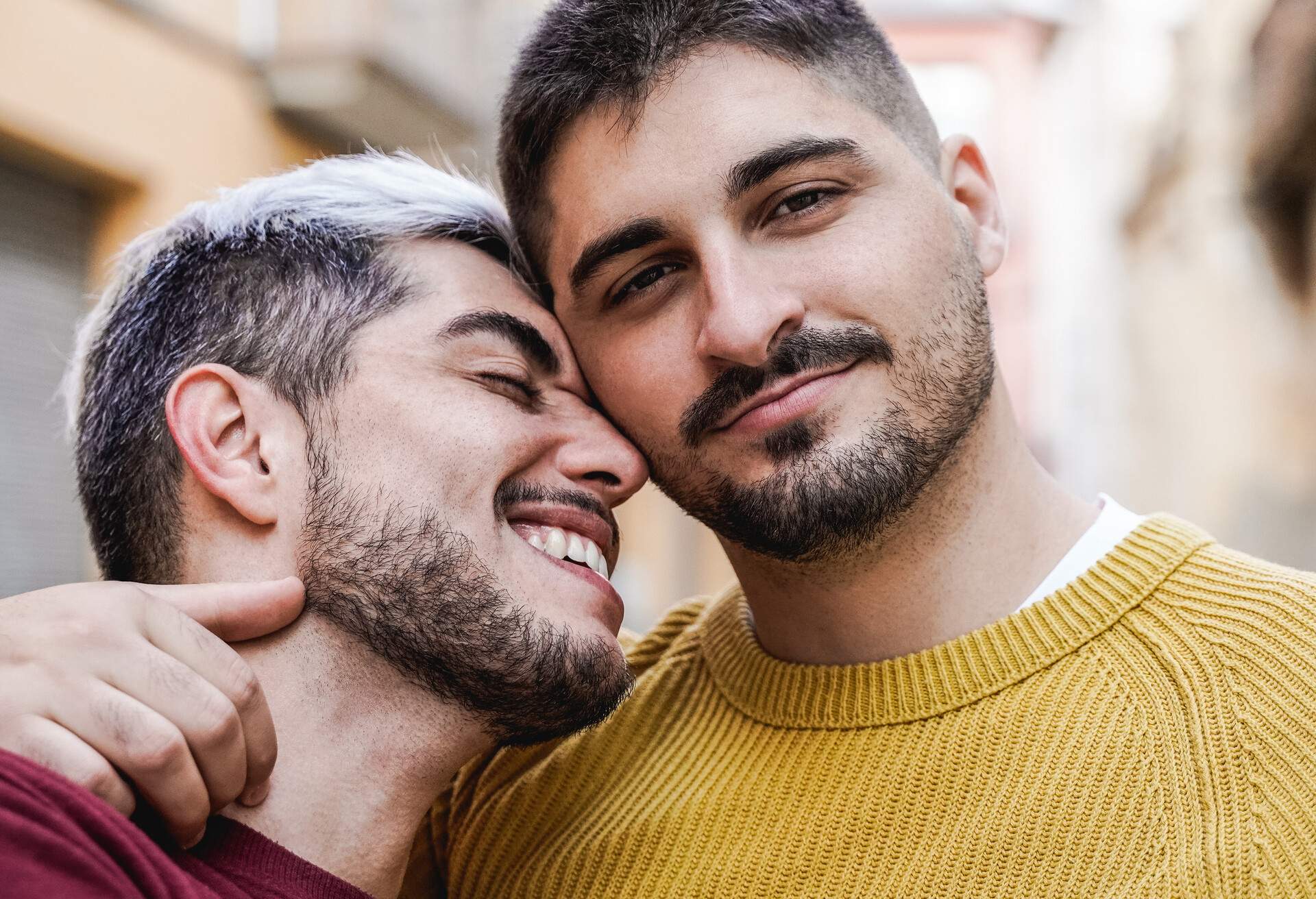 Gay male couple having tender moment outdoor in the city - LGBT love concept
