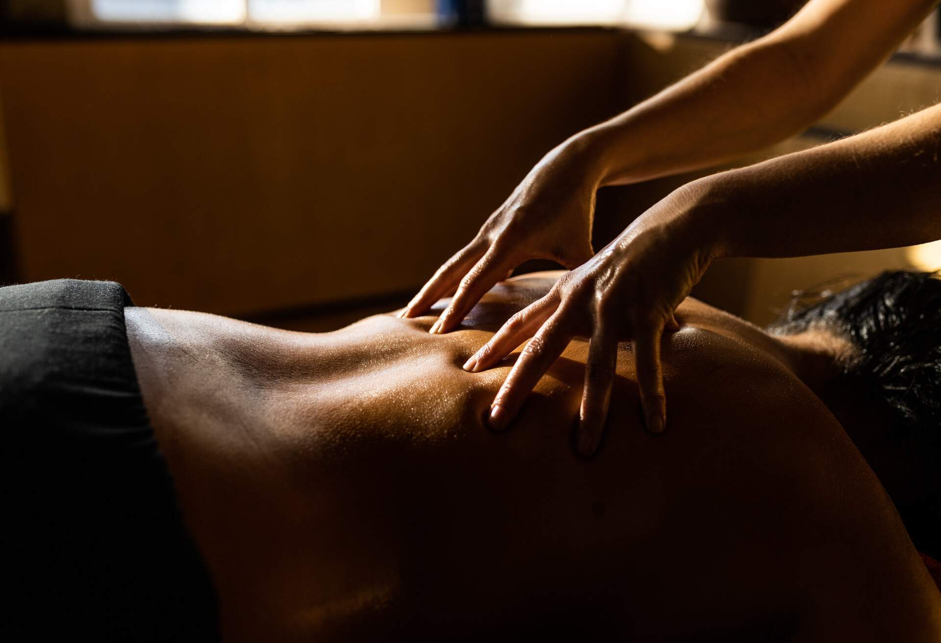Woman relaxing while receiving Ayurveda massage on her back 