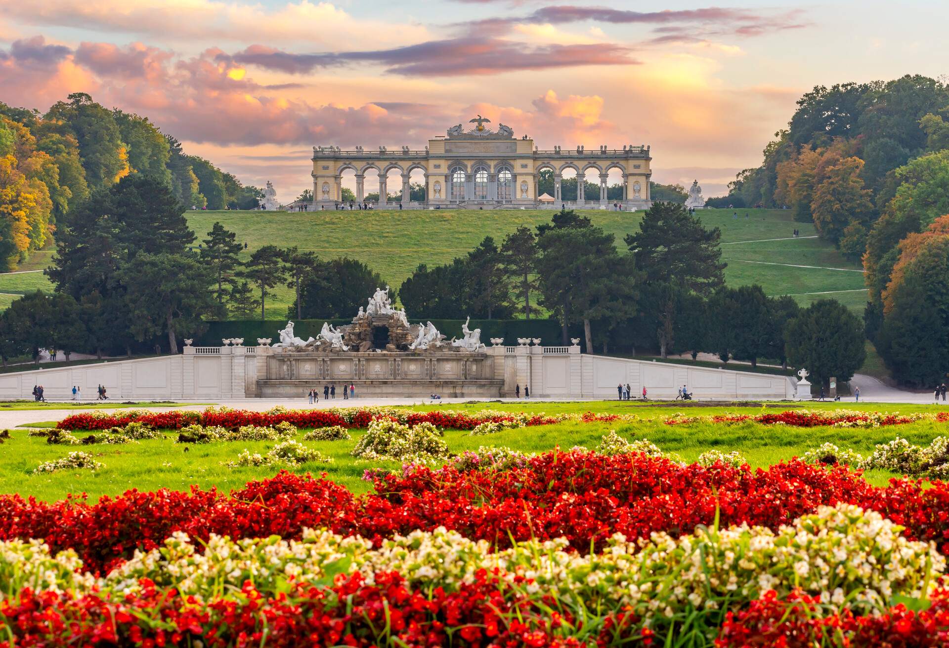 A colourful flower bed with the Gloriette Pavilion and fountain in the backdrop.