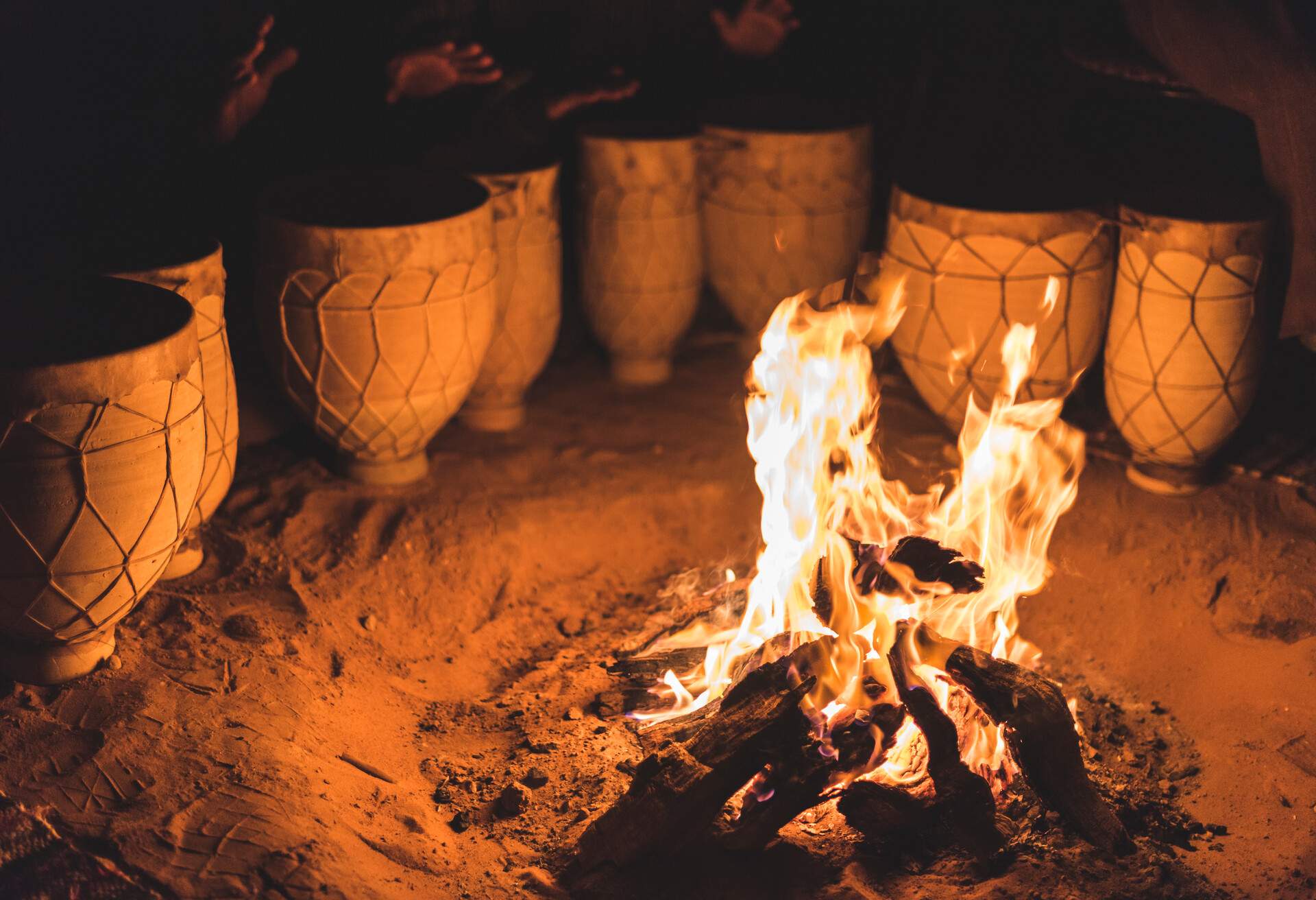 A blazing bonfire next to a set of single-head drums.