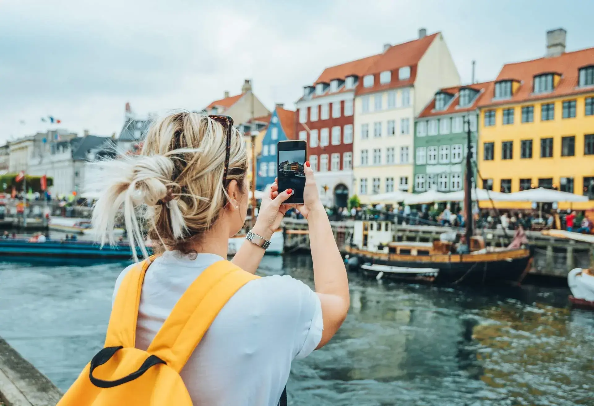 DEST_DENMARK_COPENHAGEN_NYHAVN_THEME_PEOPLE_TOURIST_TAKING_PHOTO_GettyImages-1058837752