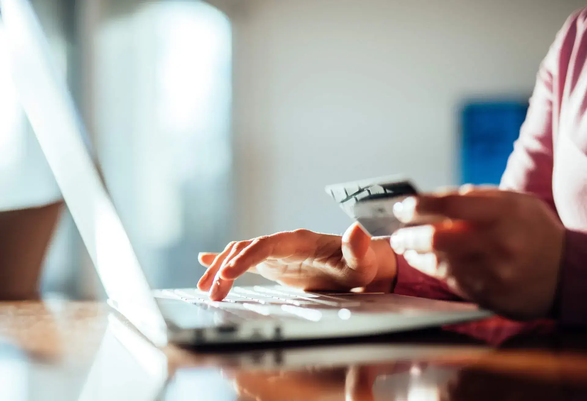 Woman shopping with a credit card at home.