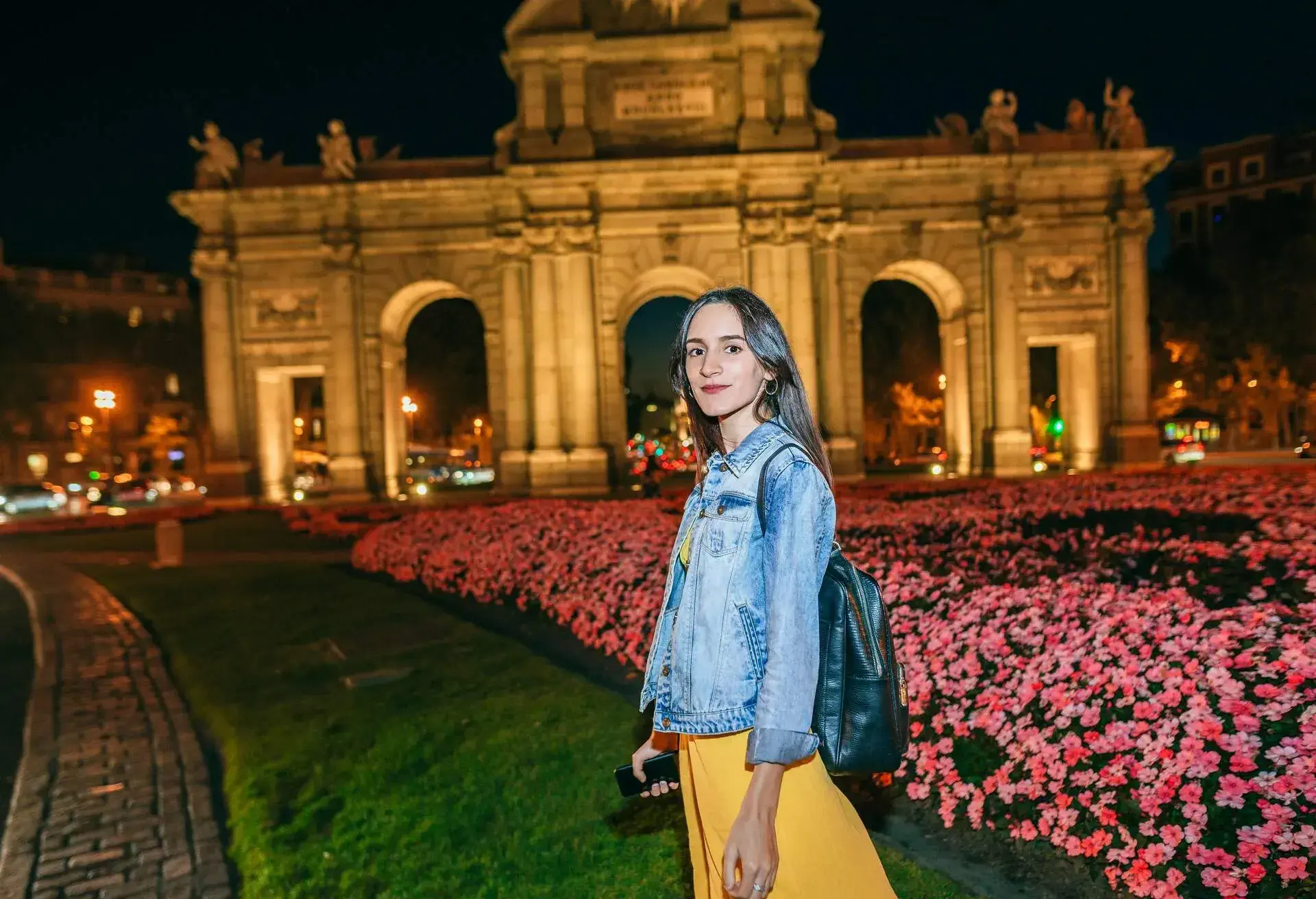 Woman walking at night near the Puerta de Alcala, Madrid.