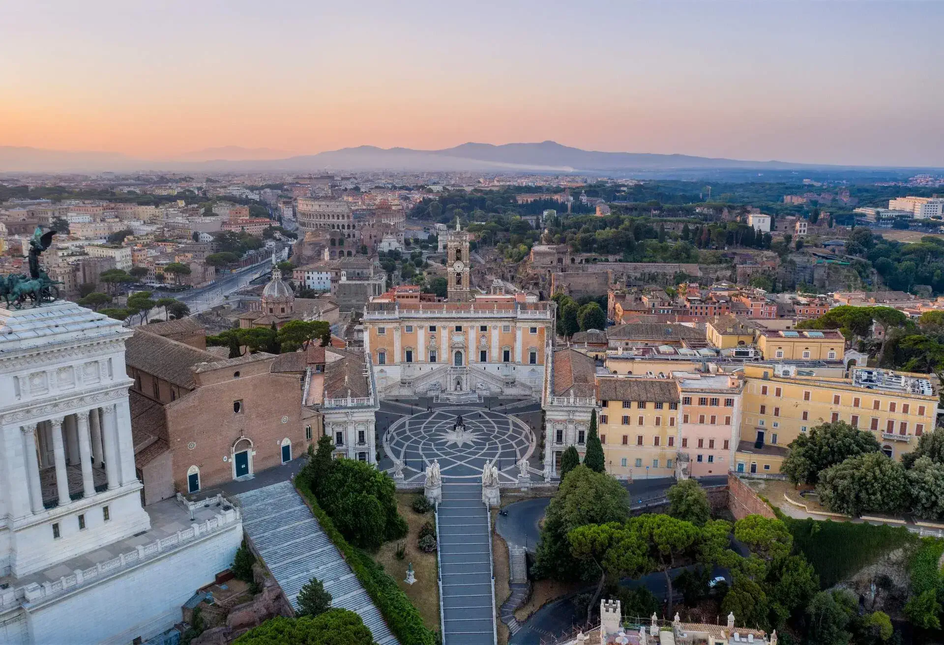 Aerial view of the Piazza del Campidoglio with Colosseum and City Buildings on background, Rome.