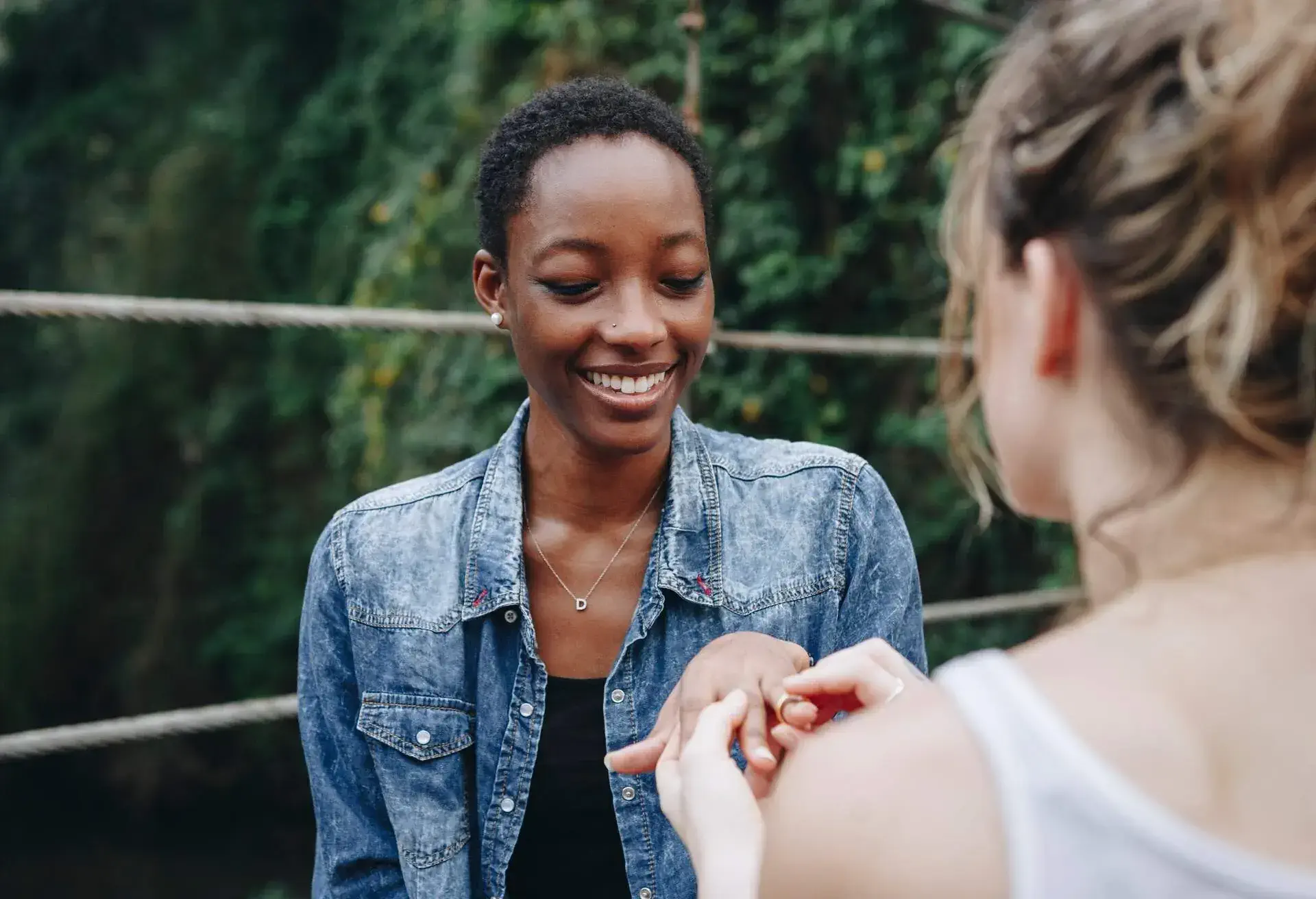 Woman proposing to her happy girlfriend outdoors love and marriage concept