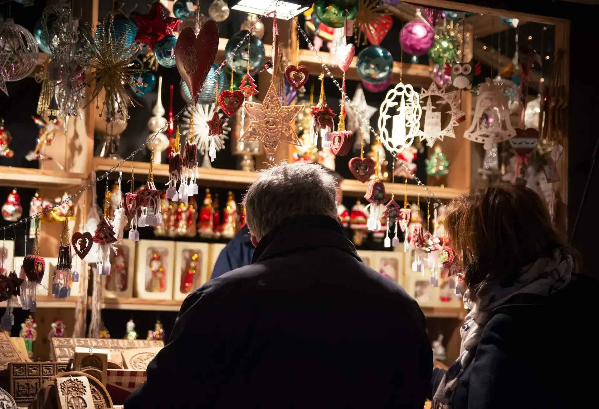 A Christmas market (also known as Christkindlmarkt, Marché de Noël, Christkindlesmarkt, Christkindlmarket, and Weihnachtsmarkt) is a street market associated with the celebration of Christmas during the four weeks of Advent. These markets originated in Germany, but are now held in many other countries, all along Europe and beyond. The history of Christmas markets goes back to the Late Middle Ages in the German-speaking part of Europe and in many parts of the former Holy Roman Empire that includes many eastern regions of France and Switzerland. In the picture, there is a couple shopping in a traditional stall of ornaments and springerle cookies molds. Springerle is a type of German biscuit with an embossed design made by pressing a mold onto rolled dough and allowing the impression to dry before baking. This preserves the detail of the surface pattern. They are most commonly seen during the Christmas season.