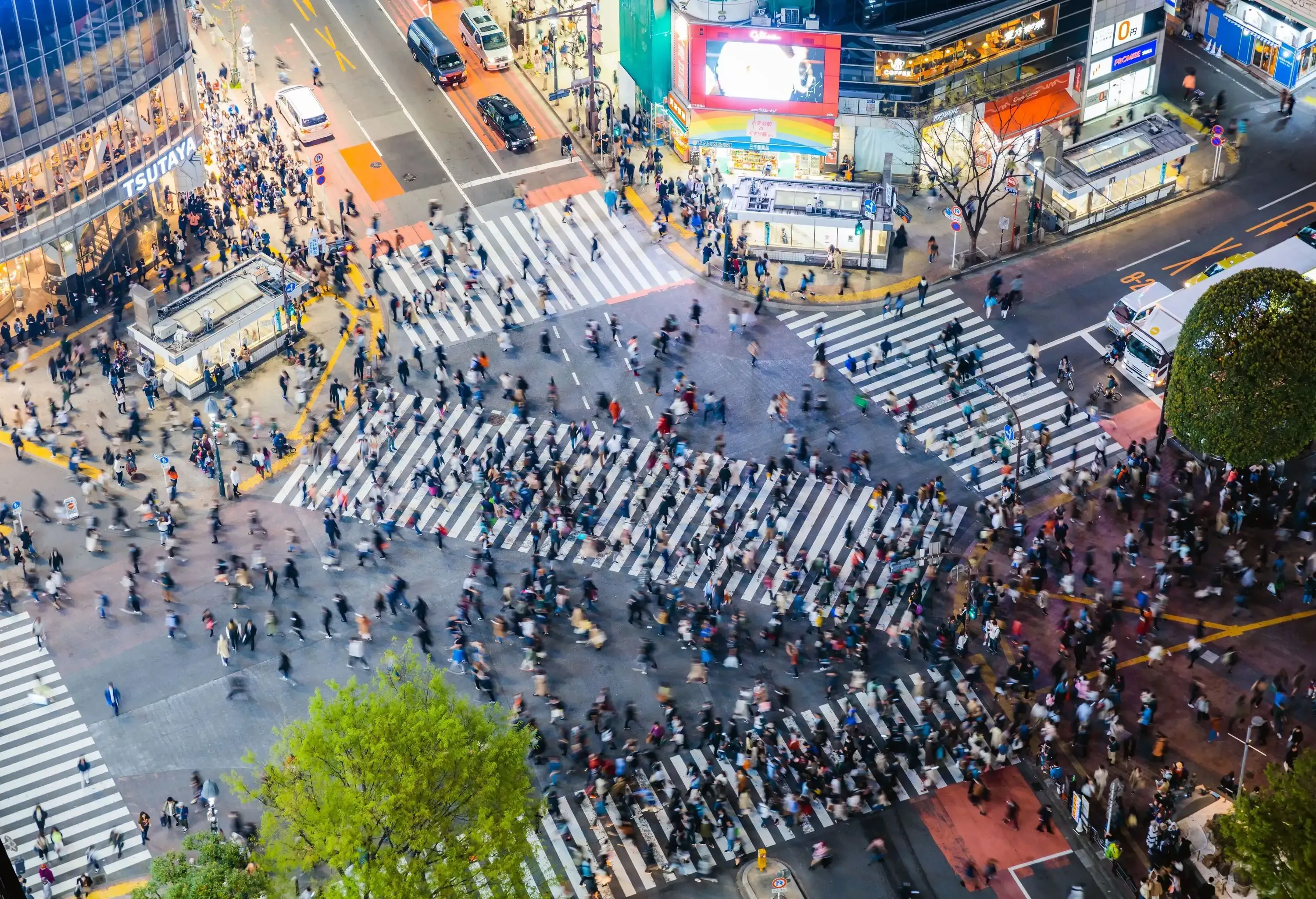 The famous Shibuya Crossing with a large crowd using the scramble intersection.